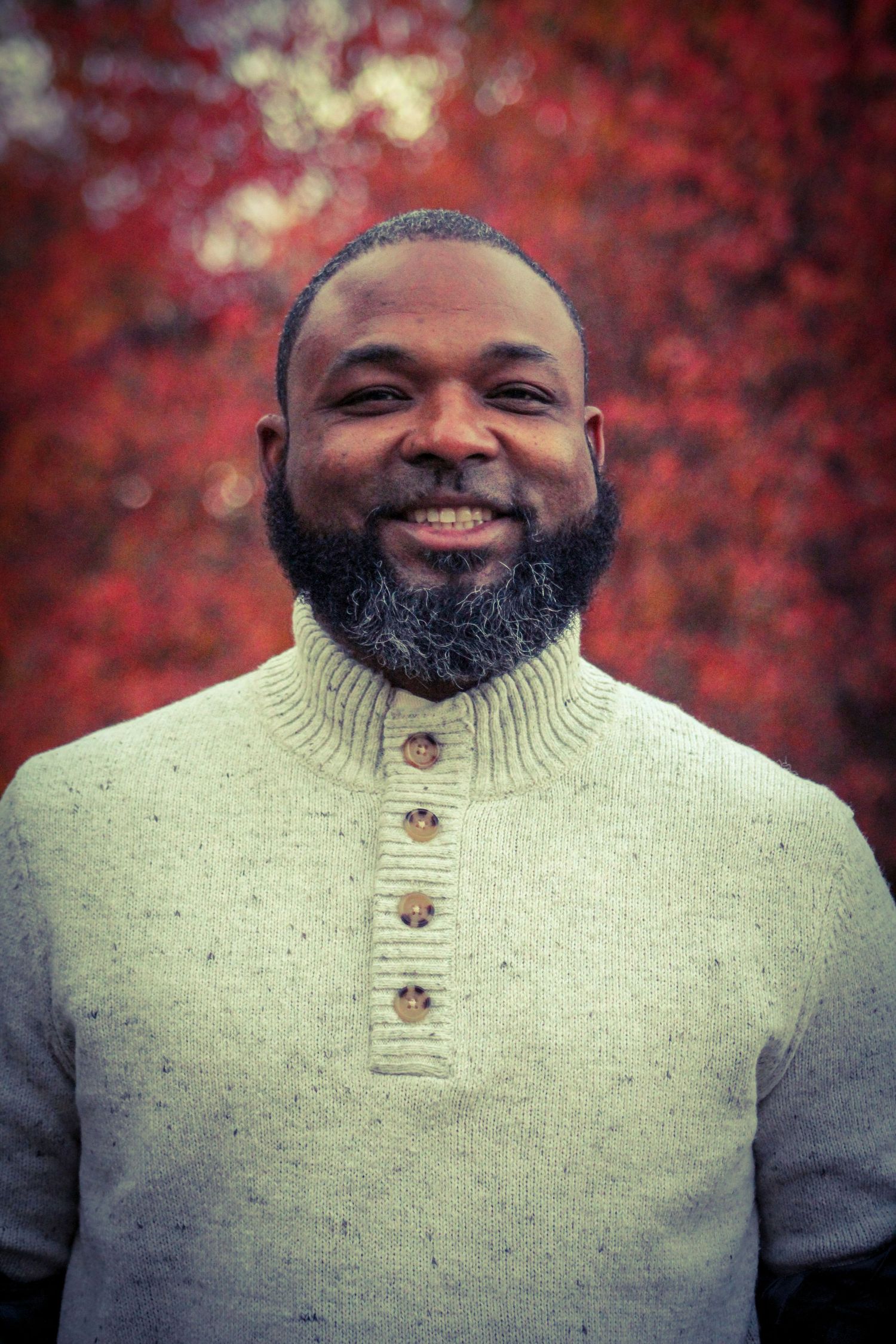 Portrait sequence of someone in a beige knit sweater smiling against autumn foliage.