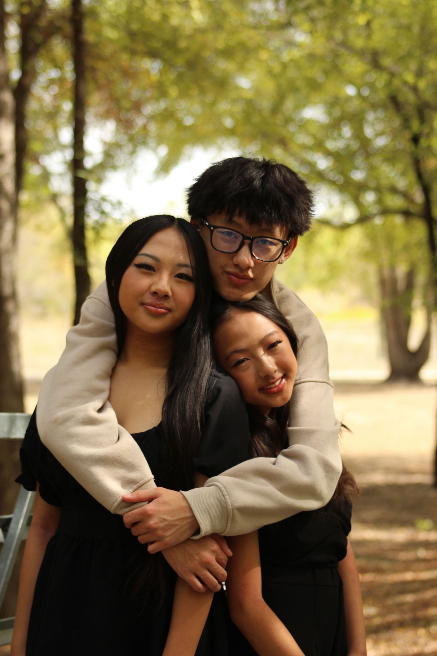 Candid moments captured between friends in a park setting with fall foliage.
