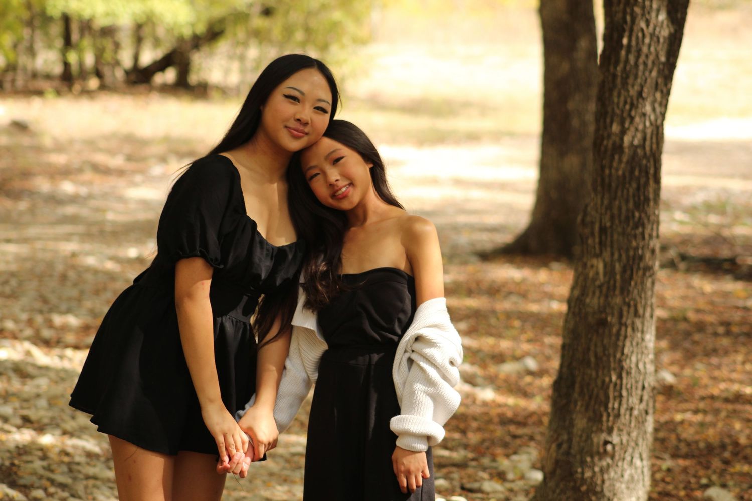 Natural outdoor portrait session with people in black outfits against autumn trees.