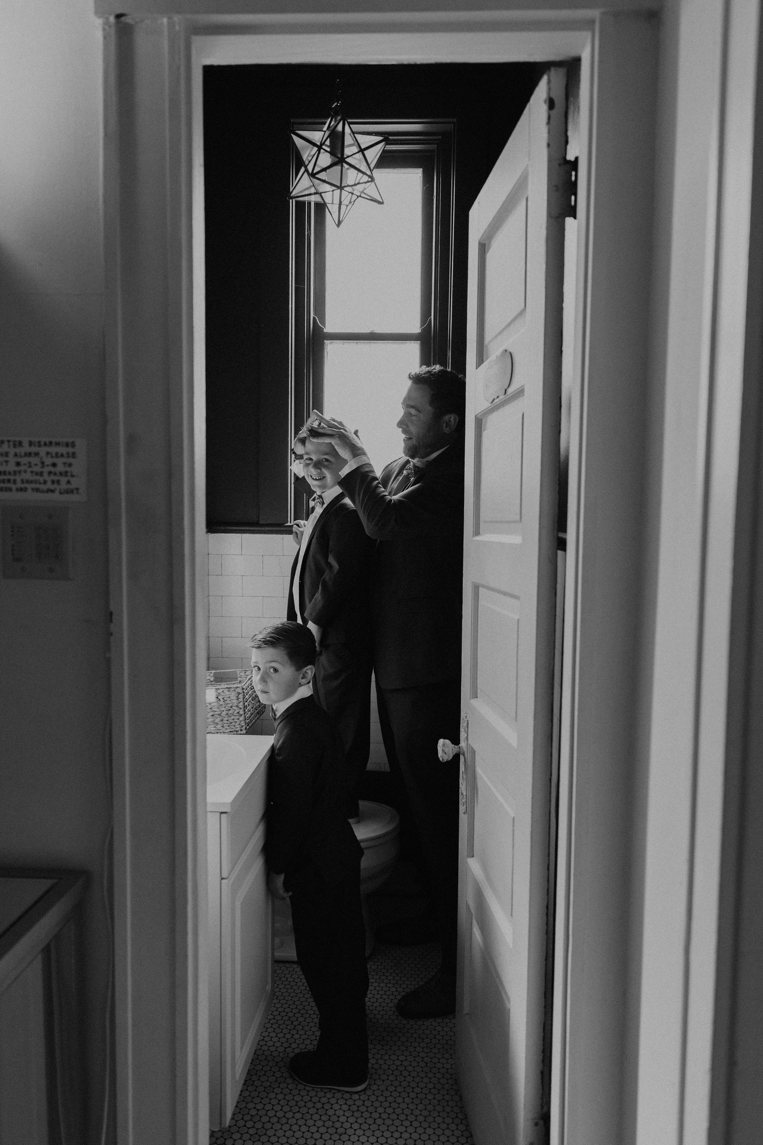 Black and white photo of two people standing in a doorway with a star decoration above.