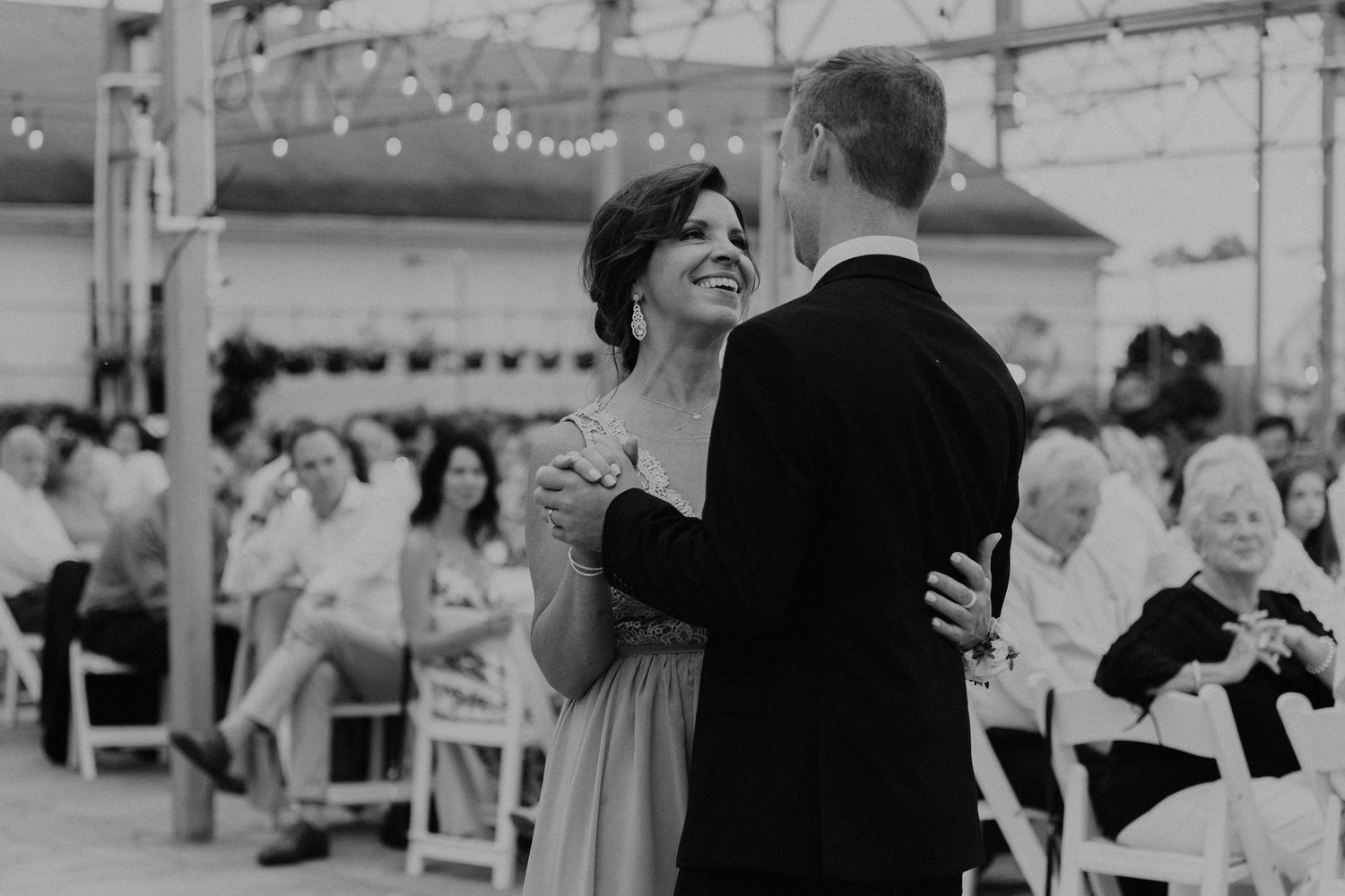 A couple shares a romantic dance moment at an outdoor reception venue.