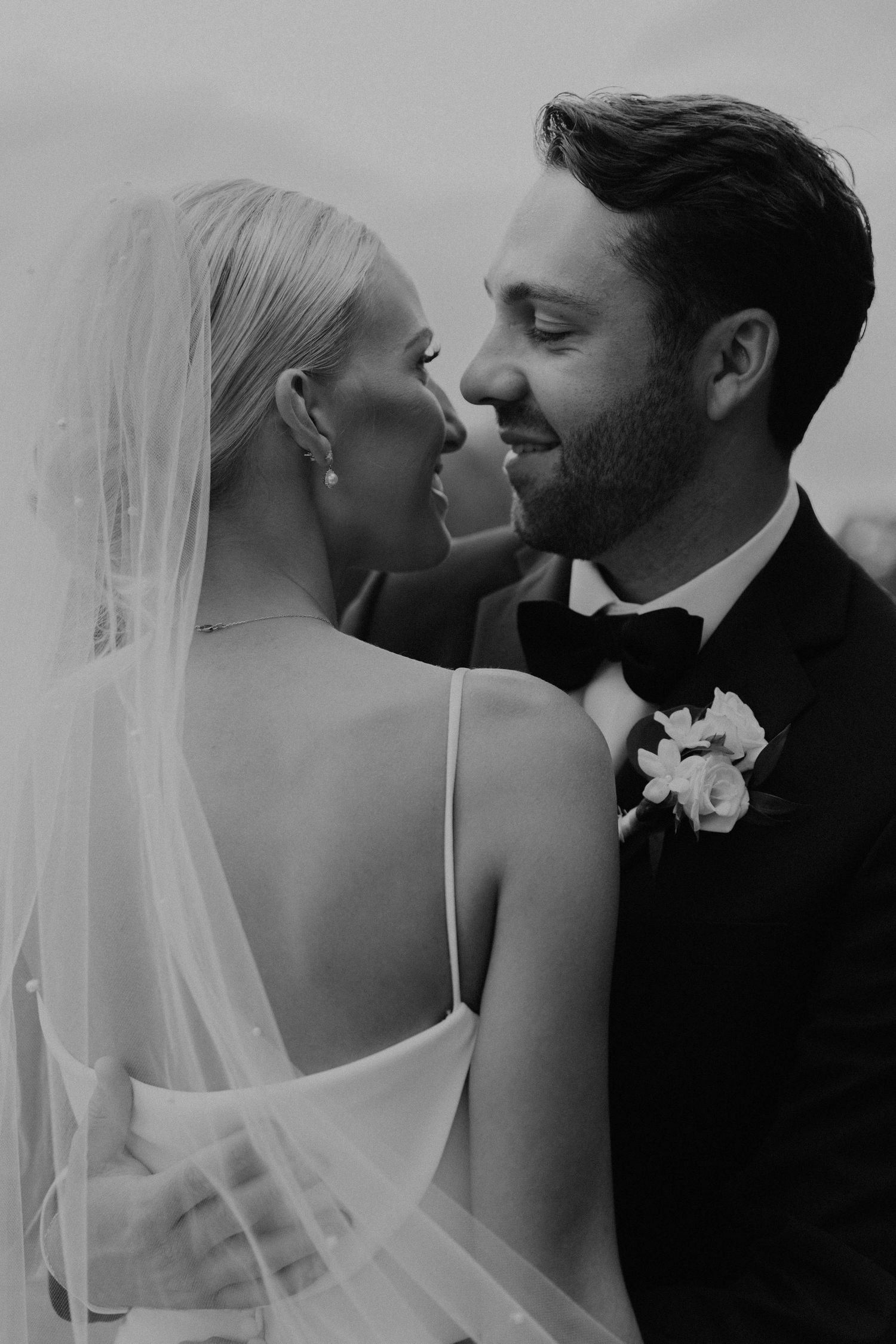 Intimate black and white portrait of newlyweds sharing a tender moment.