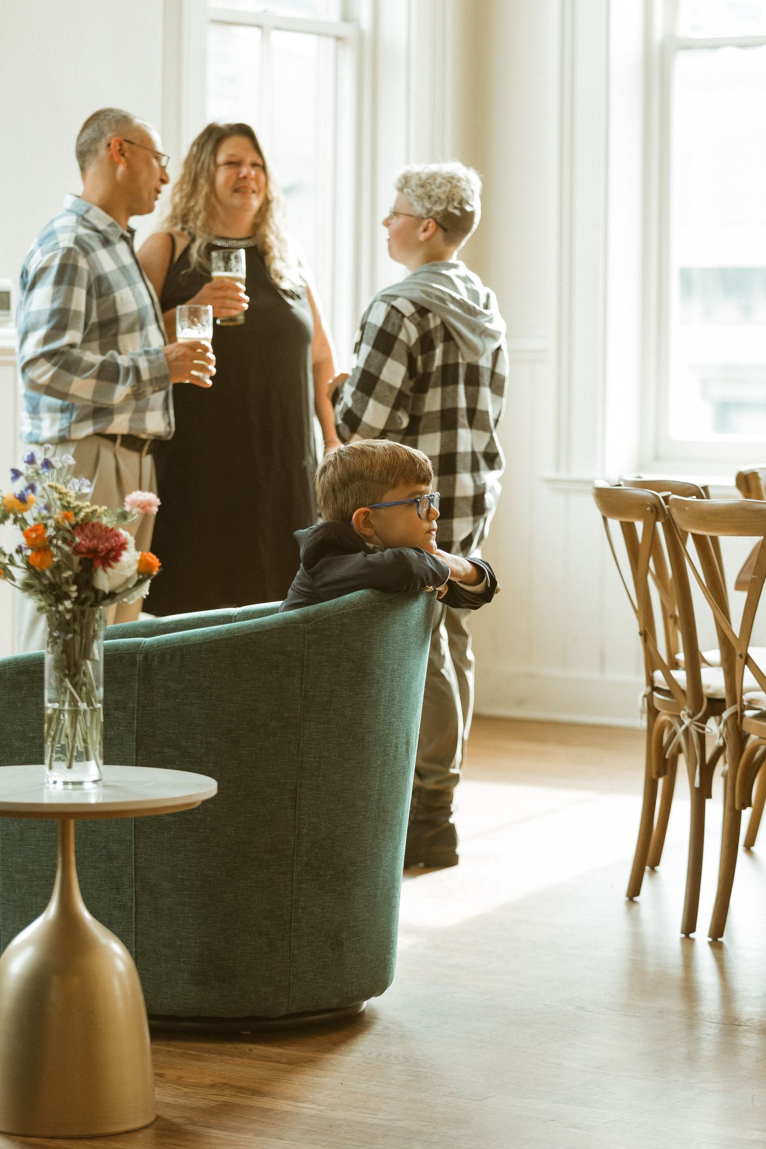 Small group chatting in a bright room with modern furnishings and floral arrangements.