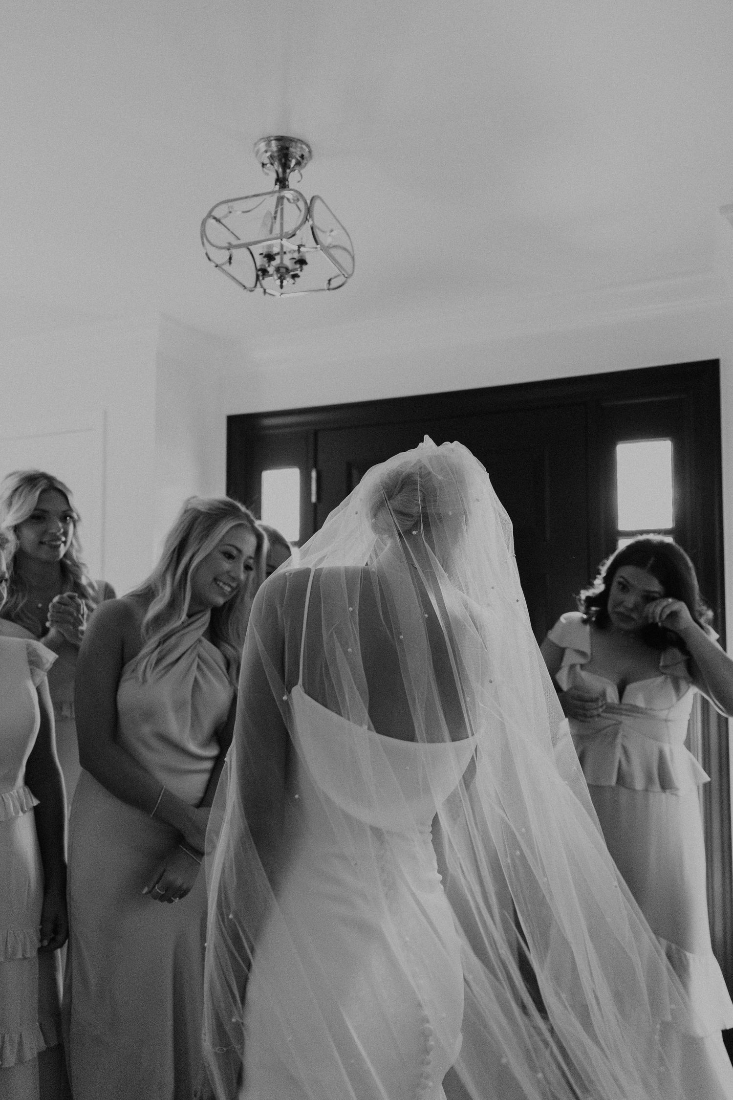 Wedding party preparations showing bridesmaids and bride in white veils getting ready for the ceremony.