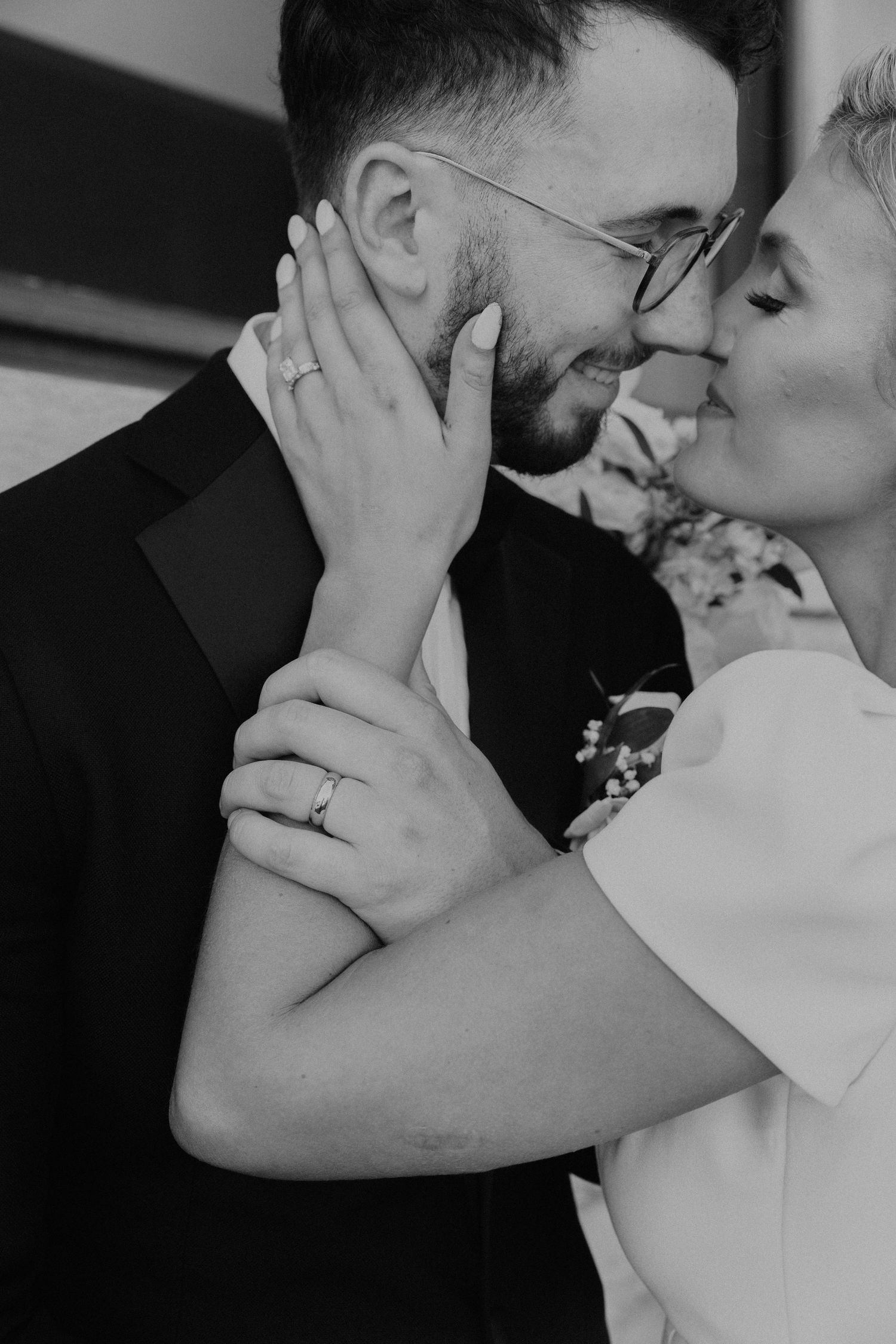 Intimate black and white portrait showing tender moment between newlyweds.