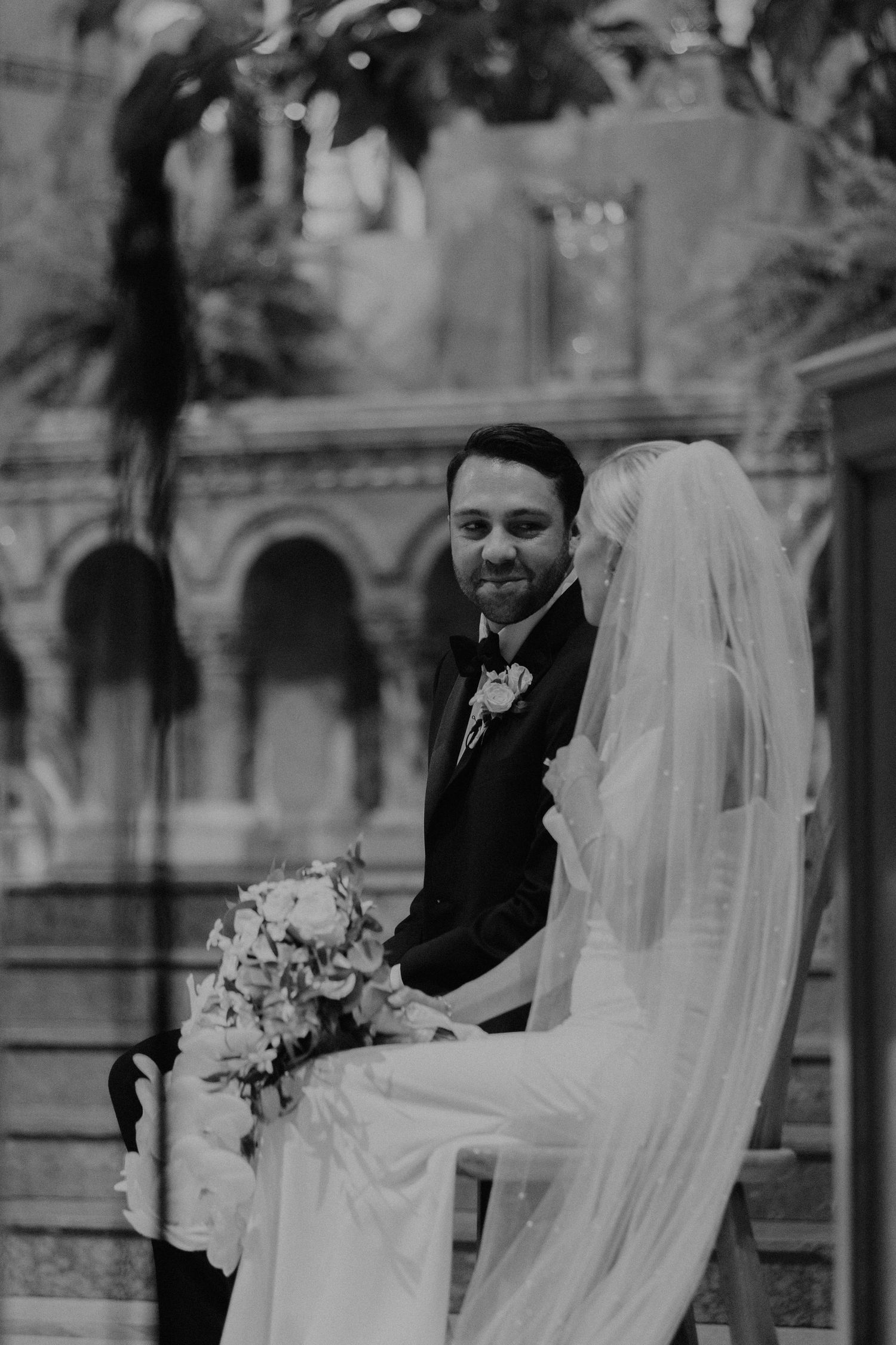 Black and white wedding portrait under historic archways.