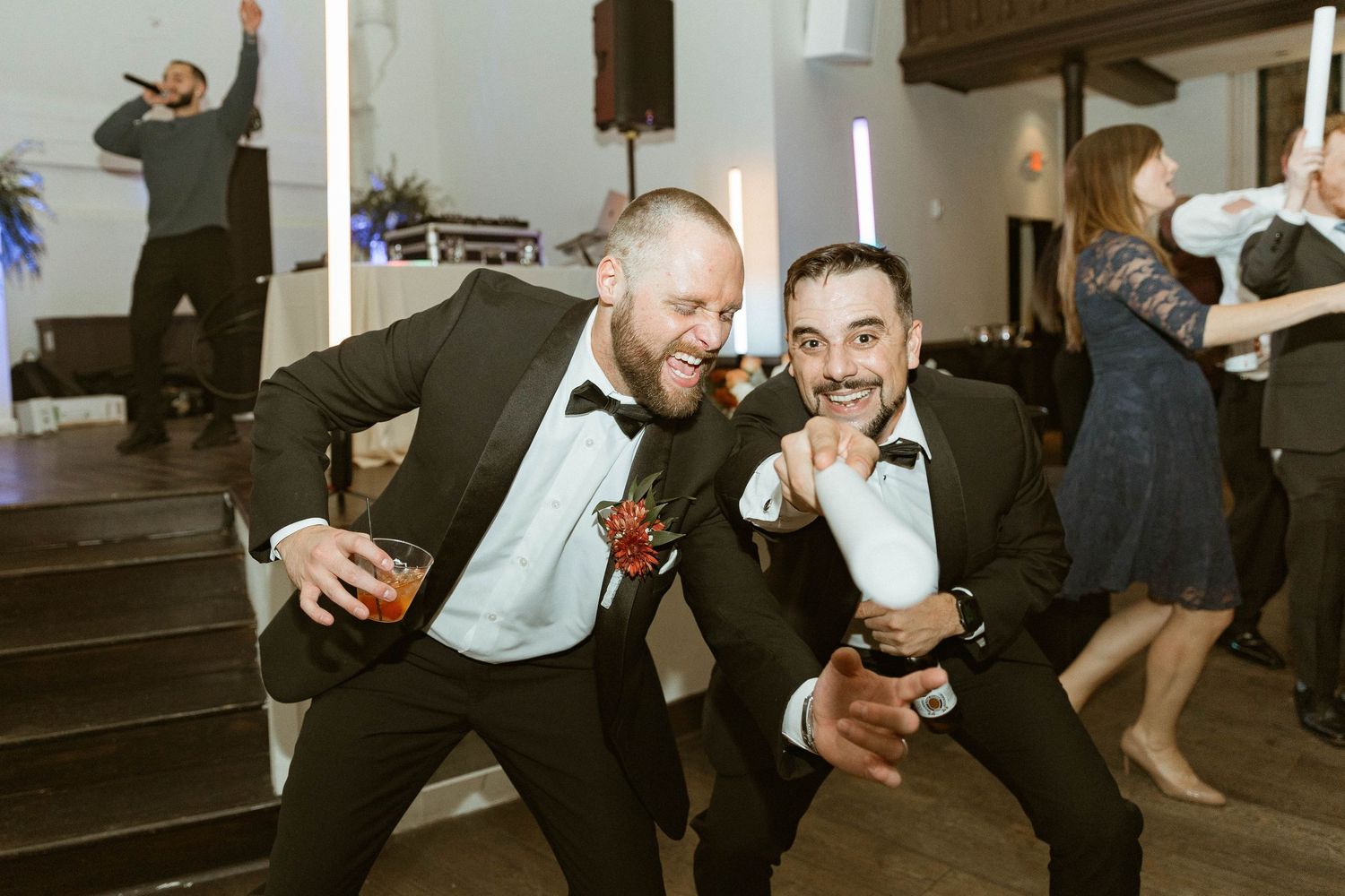Two wedding guests dancing and having fun at a reception party.