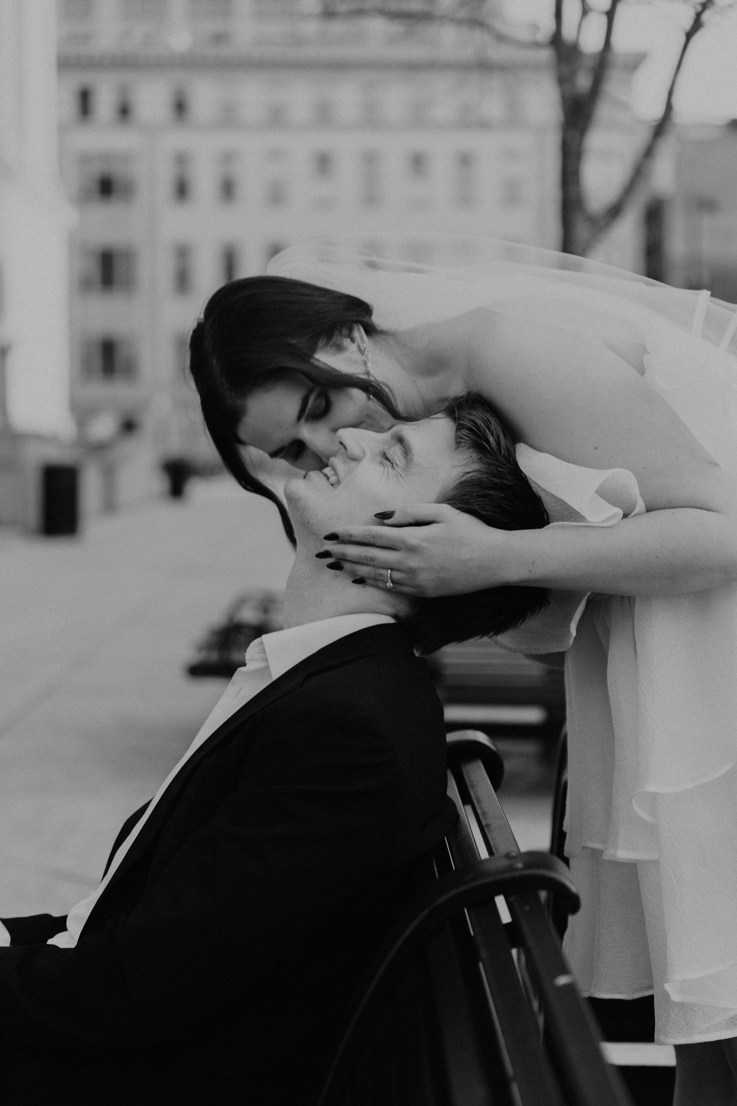 Black and white romantic moment captured between a couple in an urban setting.