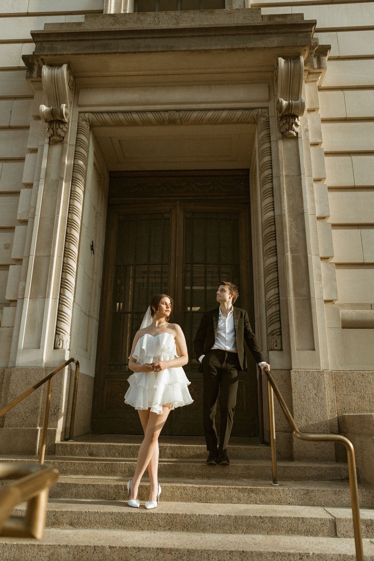 Artistic sequence showing couple walking through grand building entrance with stone columns.