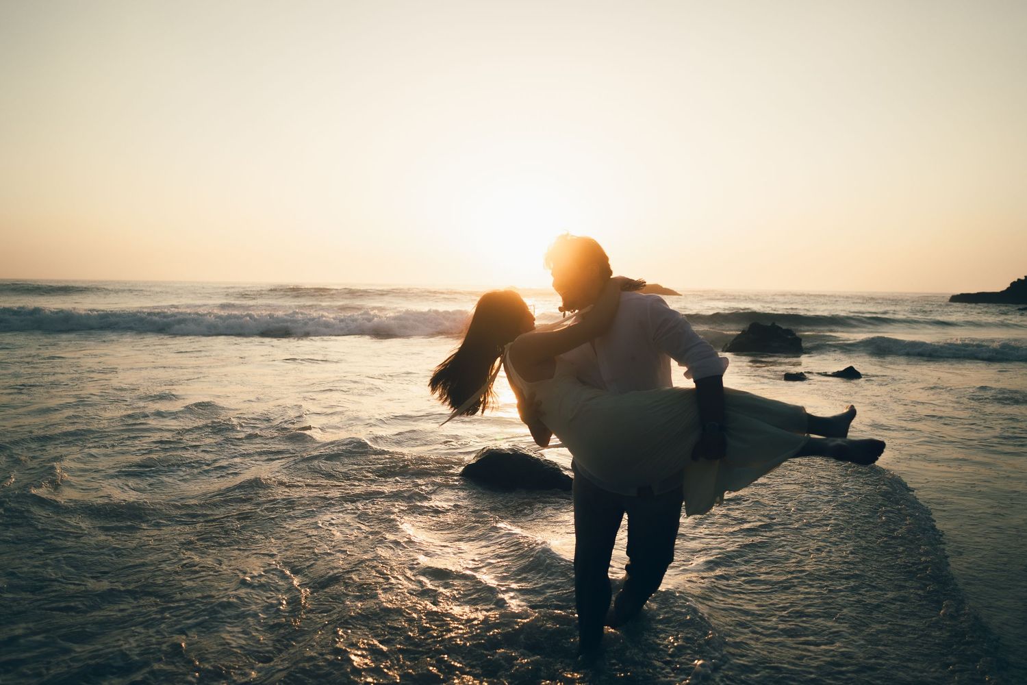 fotografia pré wedding de um casal na praia da adraga em sintra, cascais, lisboa, portugal ao por do sol. Ensaio fotografico profissional.