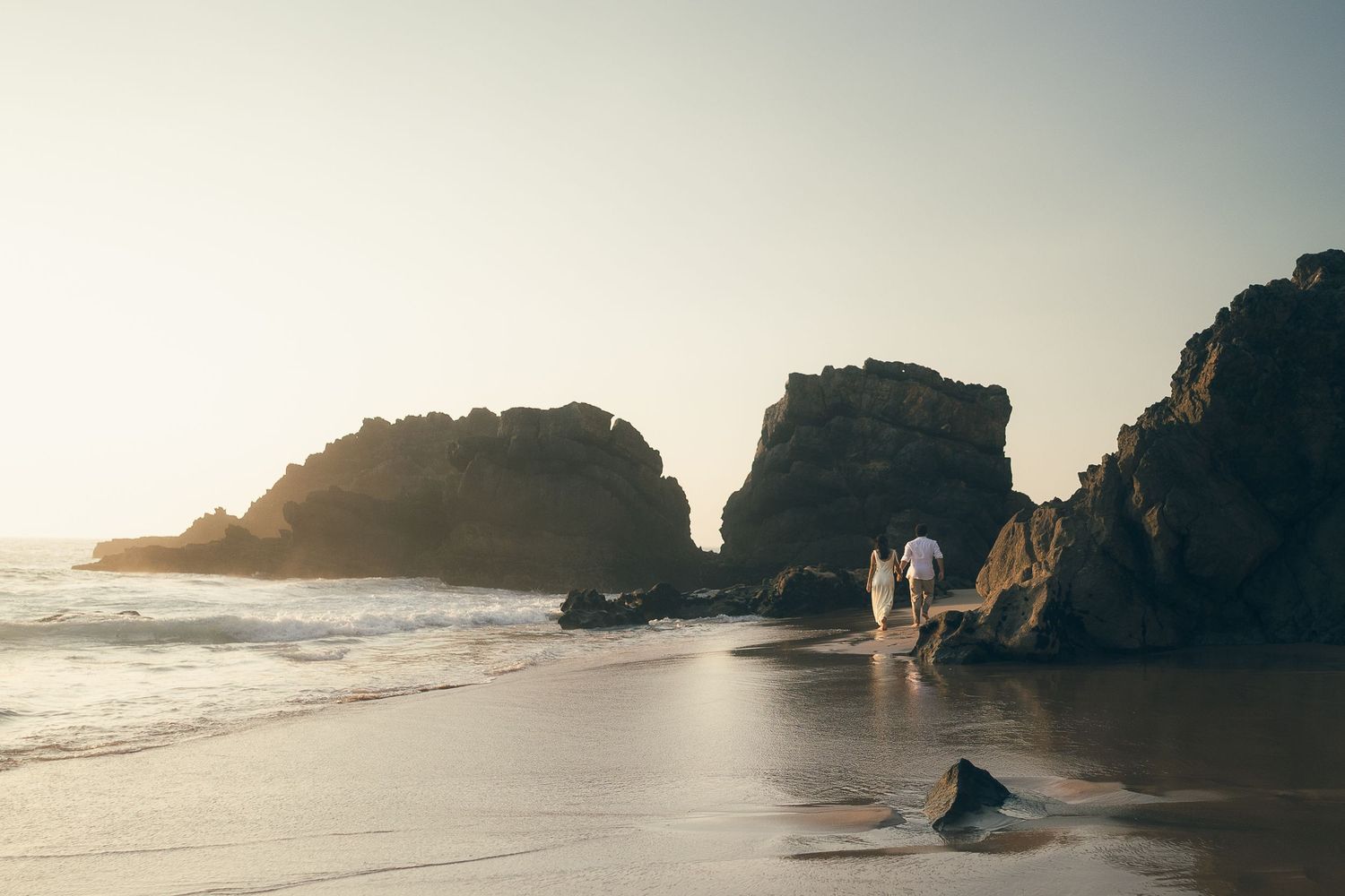 fotografia pré wedding de um casal na praia da adraga em sintra, cascais, lisboa, portugal ao por do sol. Ensaio fotografico profissional.
