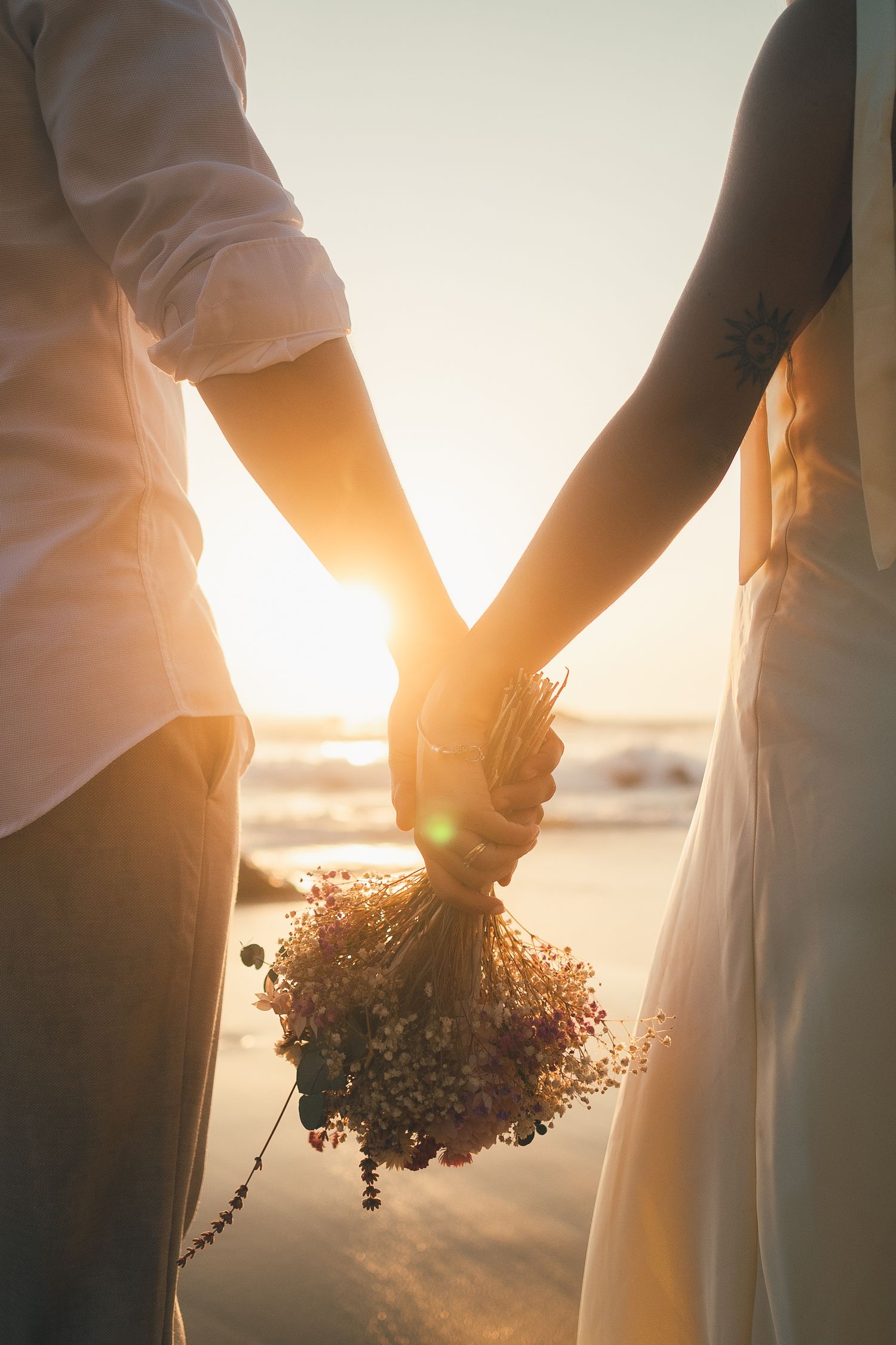 fotografia pré wedding de um casal na praia da adraga em sintra, cascais, lisboa, portugal ao por do sol. Ensaio fotografico profissional.
