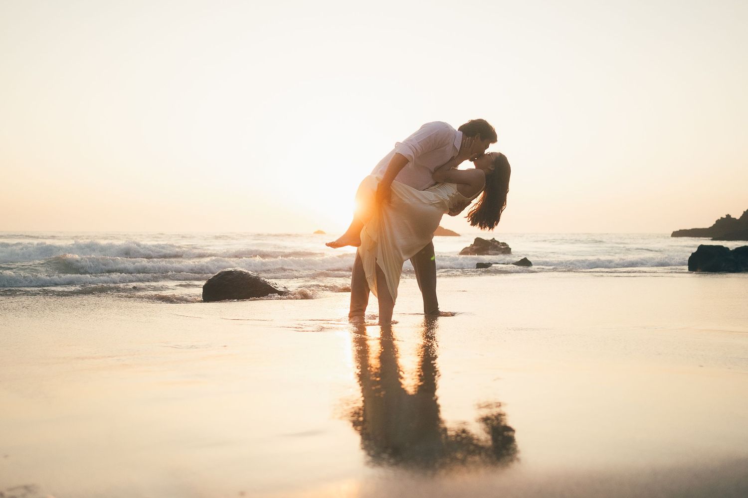 fotografia pré wedding de um casal na praia da adraga em sintra, cascais, lisboa, portugal ao por do sol. Ensaio fotografico profissional.