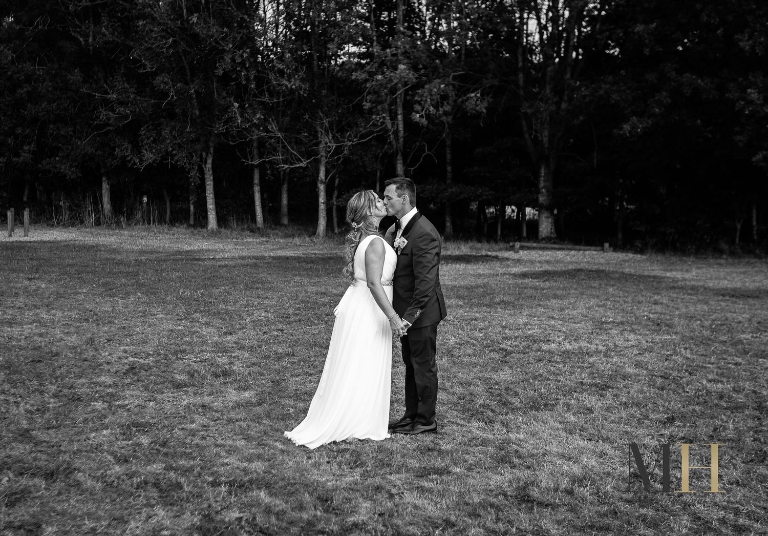 A black and white panoramic sequence shows a couple in wedding attire walking together across an open field.