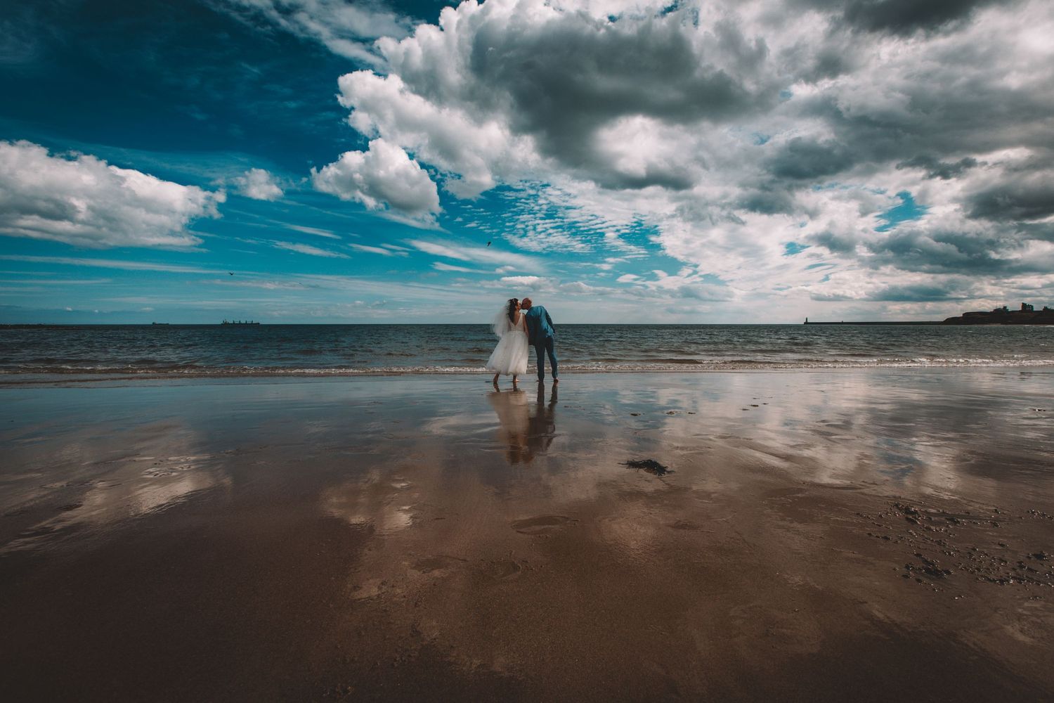 Serene beach landscape panorama with dramatic cloudy sky over sand.