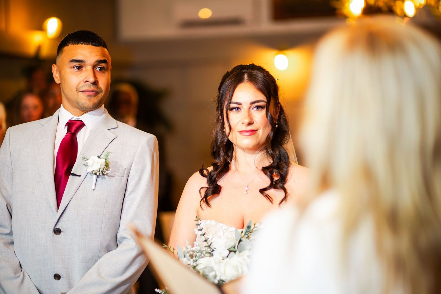 Joyful wedding celebration scene with warm lighting and elegant decor at an indoor reception venue.