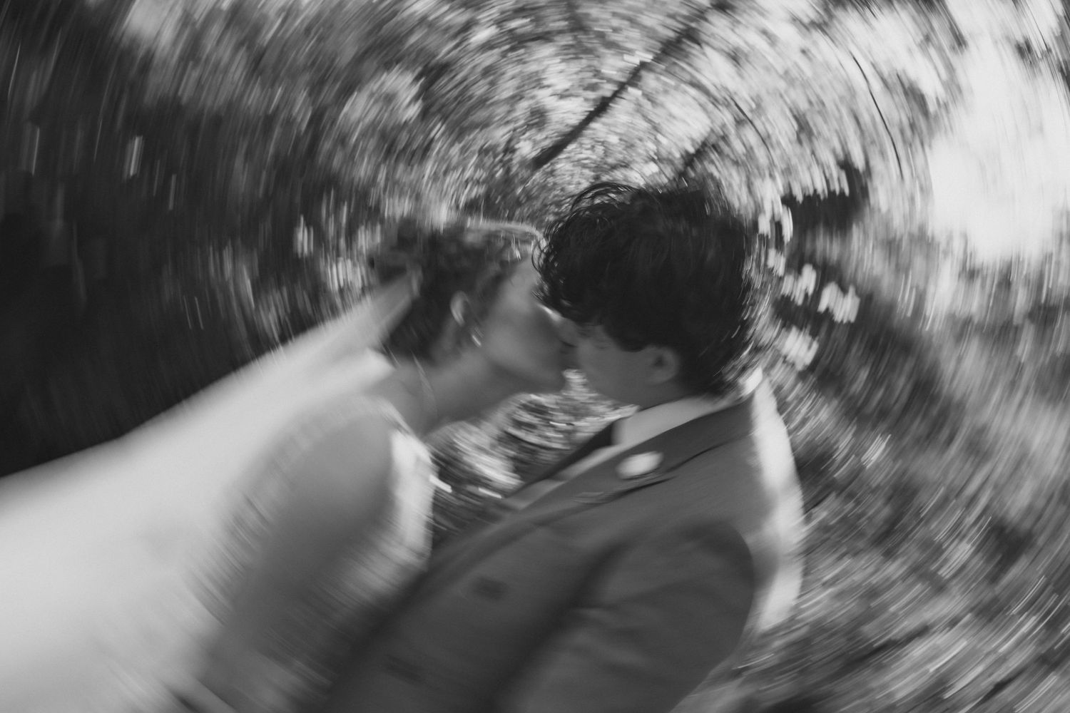 Romantic & emotional wedding photos, bride & groom motion blur photos, bride & groom kissing in a radial motion blur, Saylorsburg PA, B&W