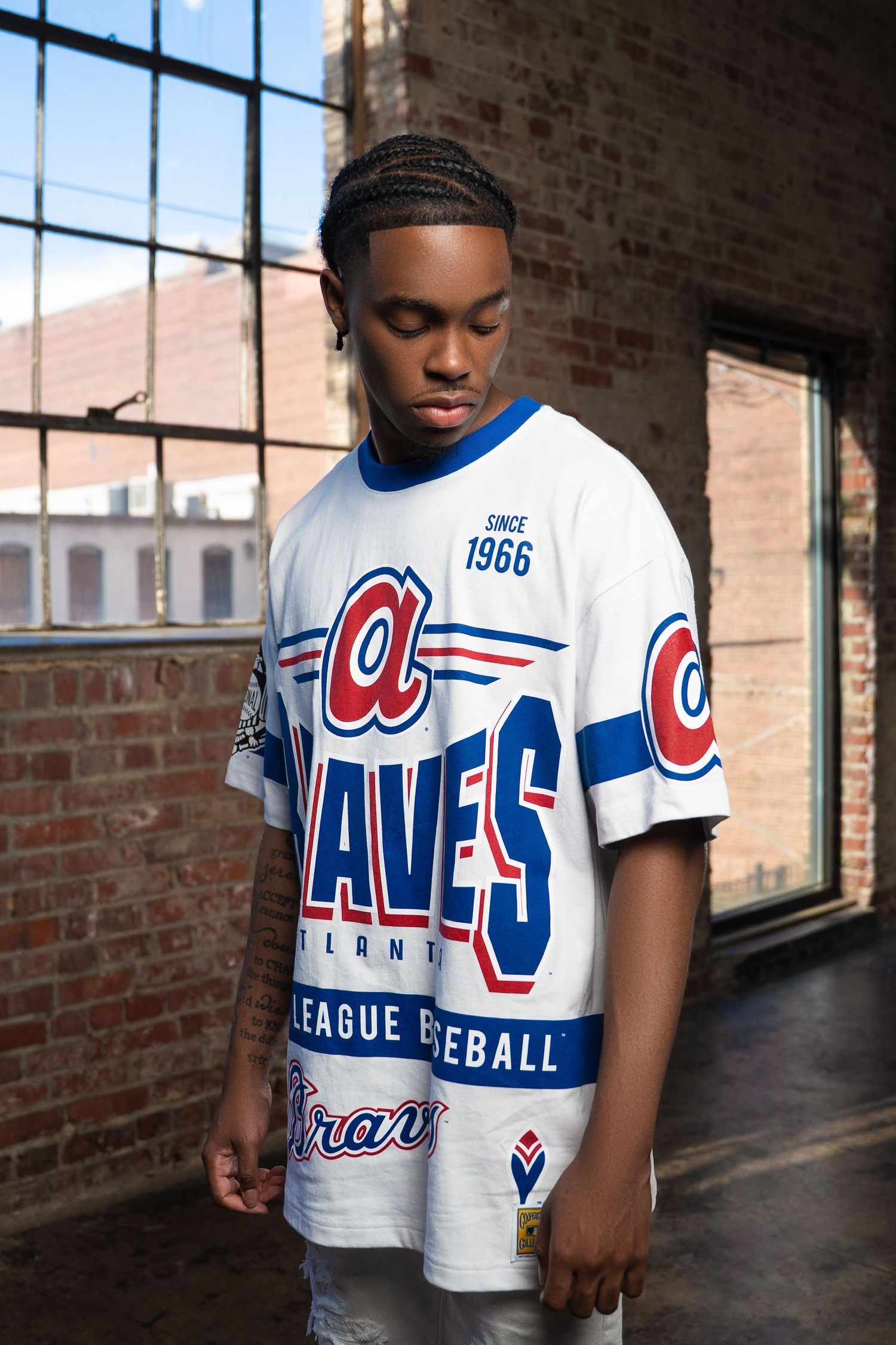 Vintage Atlanta Braves jersey with classic 1966 design in white and blue displayed in brick interior.
