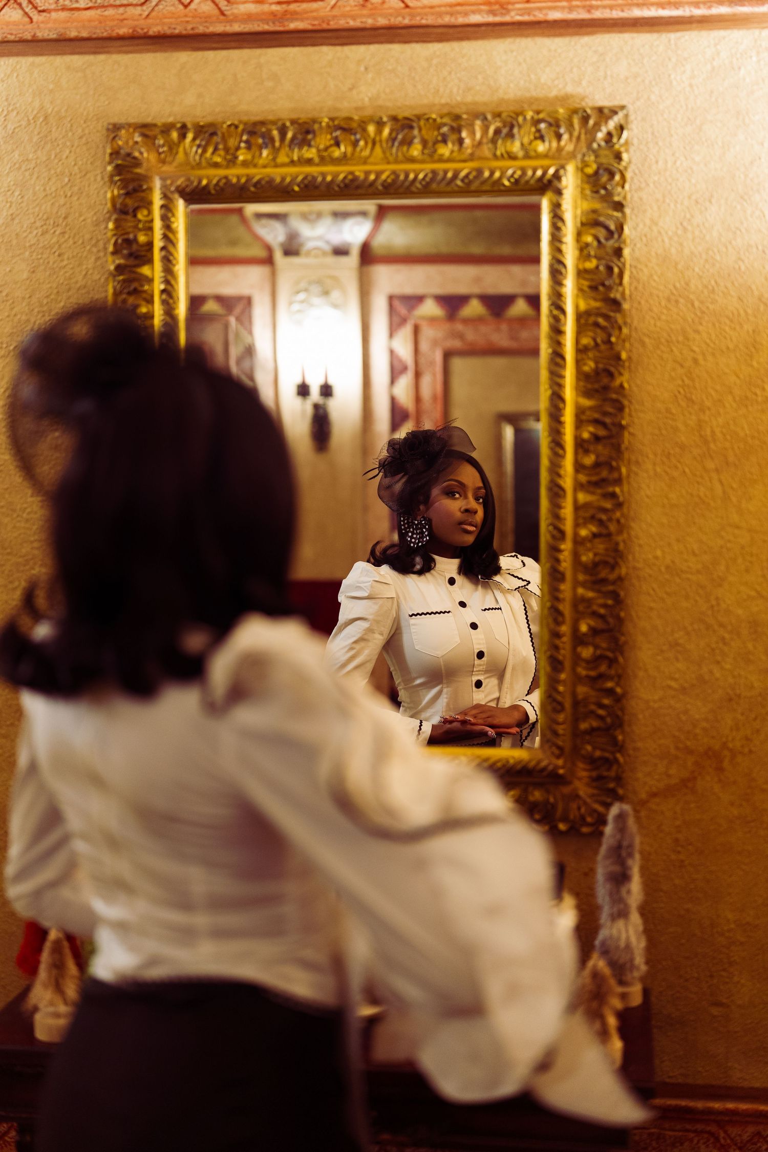 A sequence of mirror reflections shows a figure in a white shirt creating a repeating pattern in an ornate gold frame.