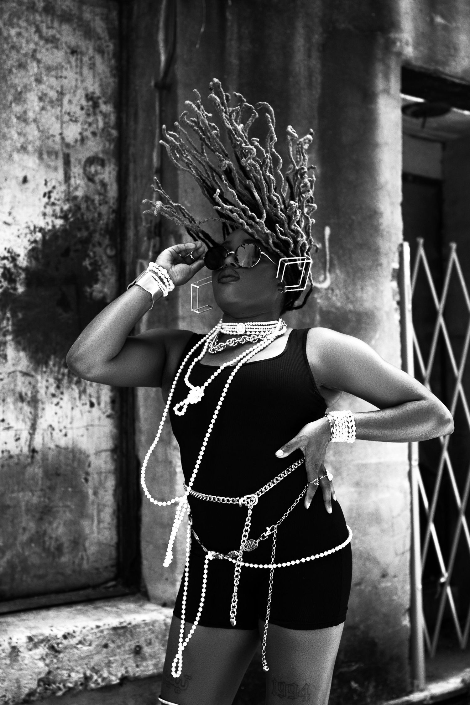 Artistic black and white portrait with dramatic chain accessories and creative headpiece.