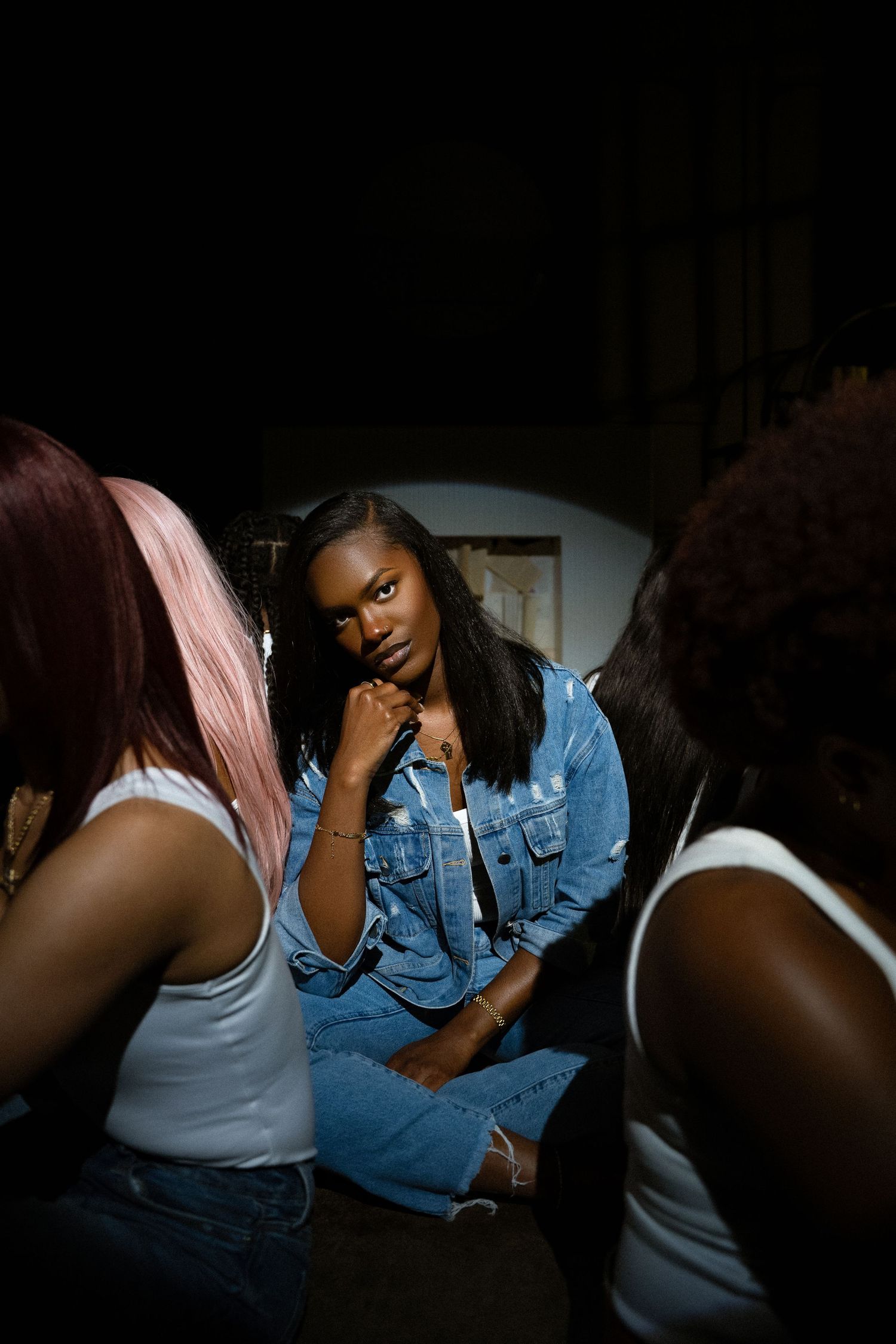 A series of dark moody photographs showing two people sitting together in denim and white clothing.