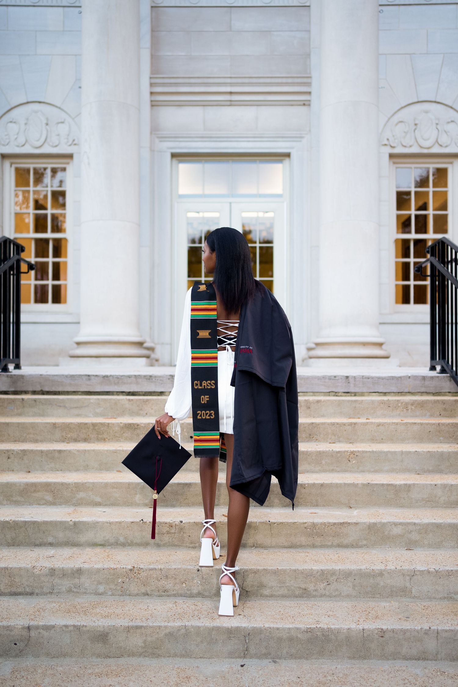 Graduation photo series on white stone steps with classical columns and windows.