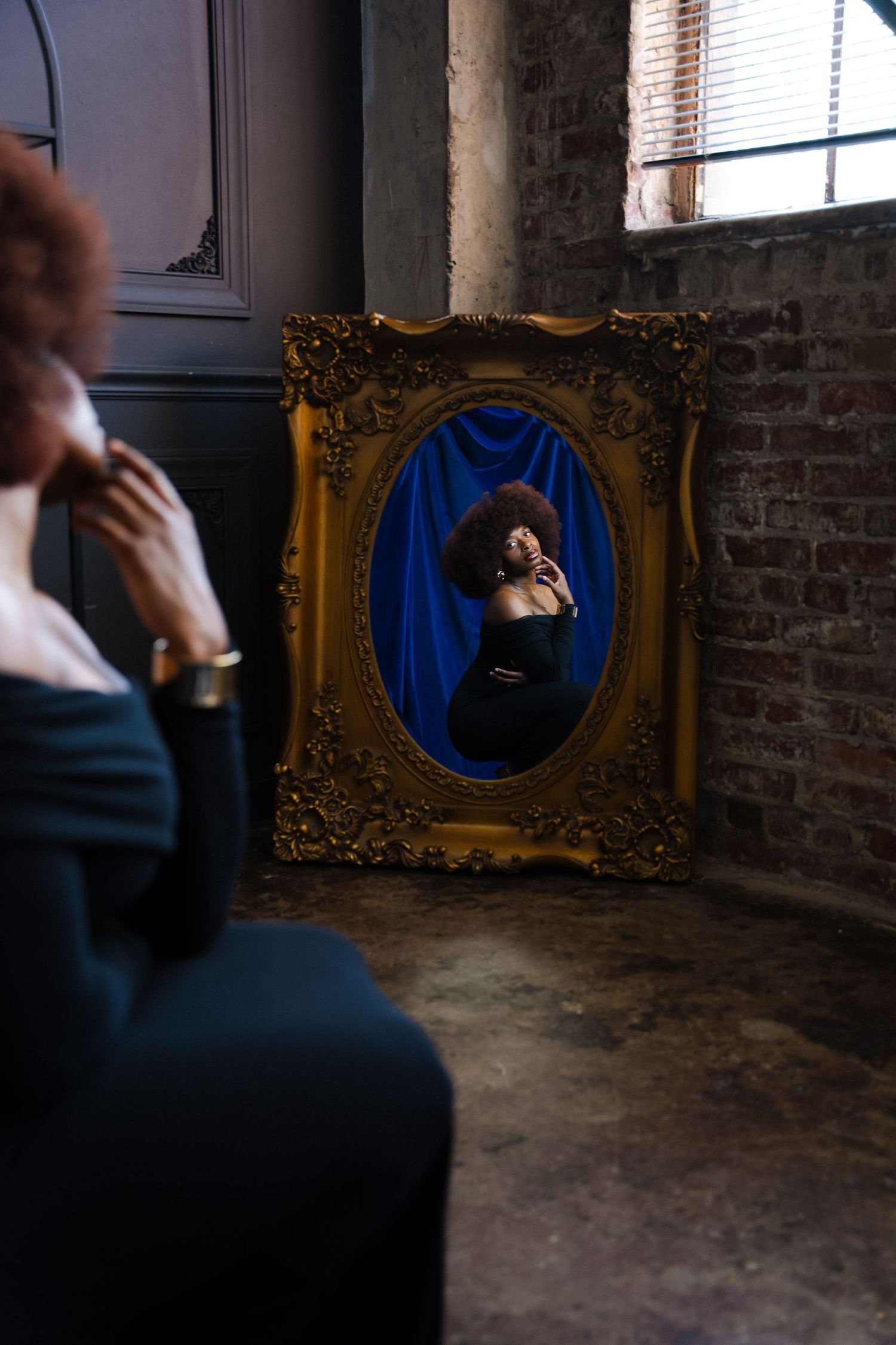 Artistic triptych showing a person in blue against a brick wall with ornate gold frames in moody lighting.