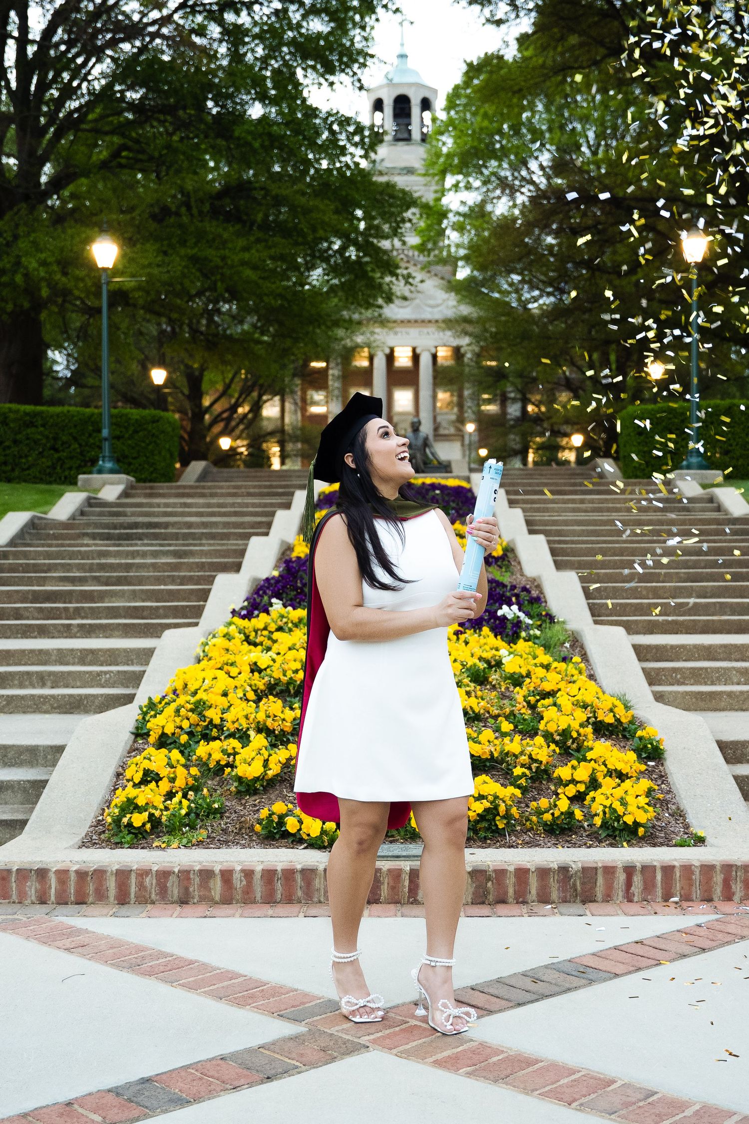Campus stairs with vibrant yellow flowers and brick pathways at dusk.