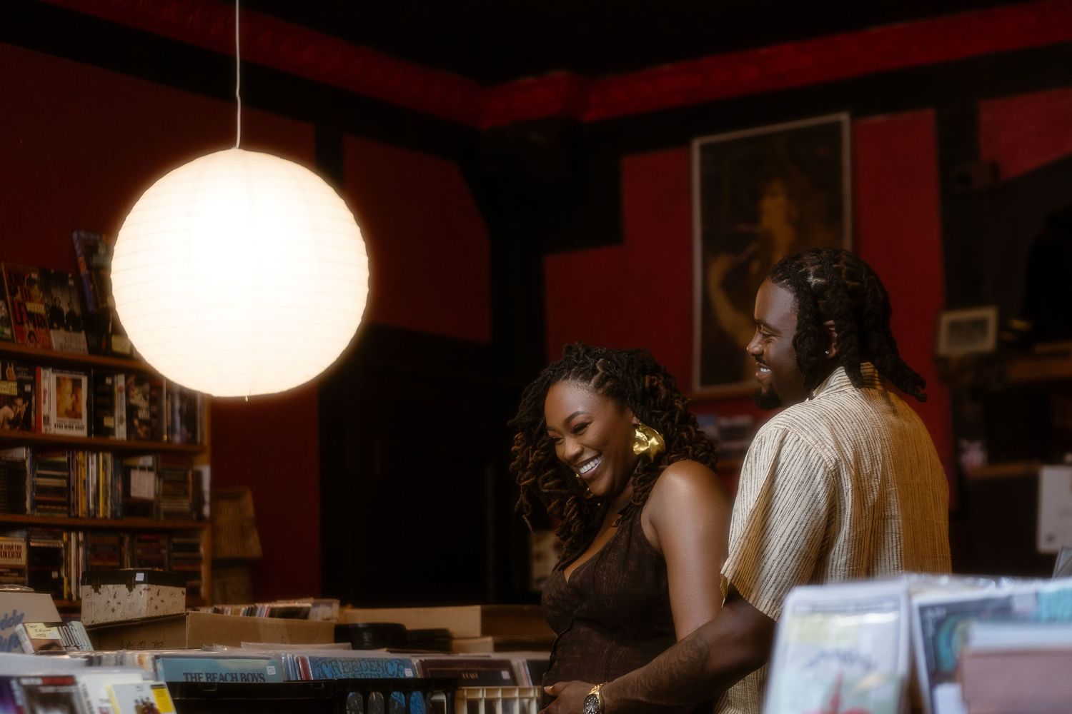 A dimly lit interior space with bookshelves and pendant lights creating an intimate atmosphere.
