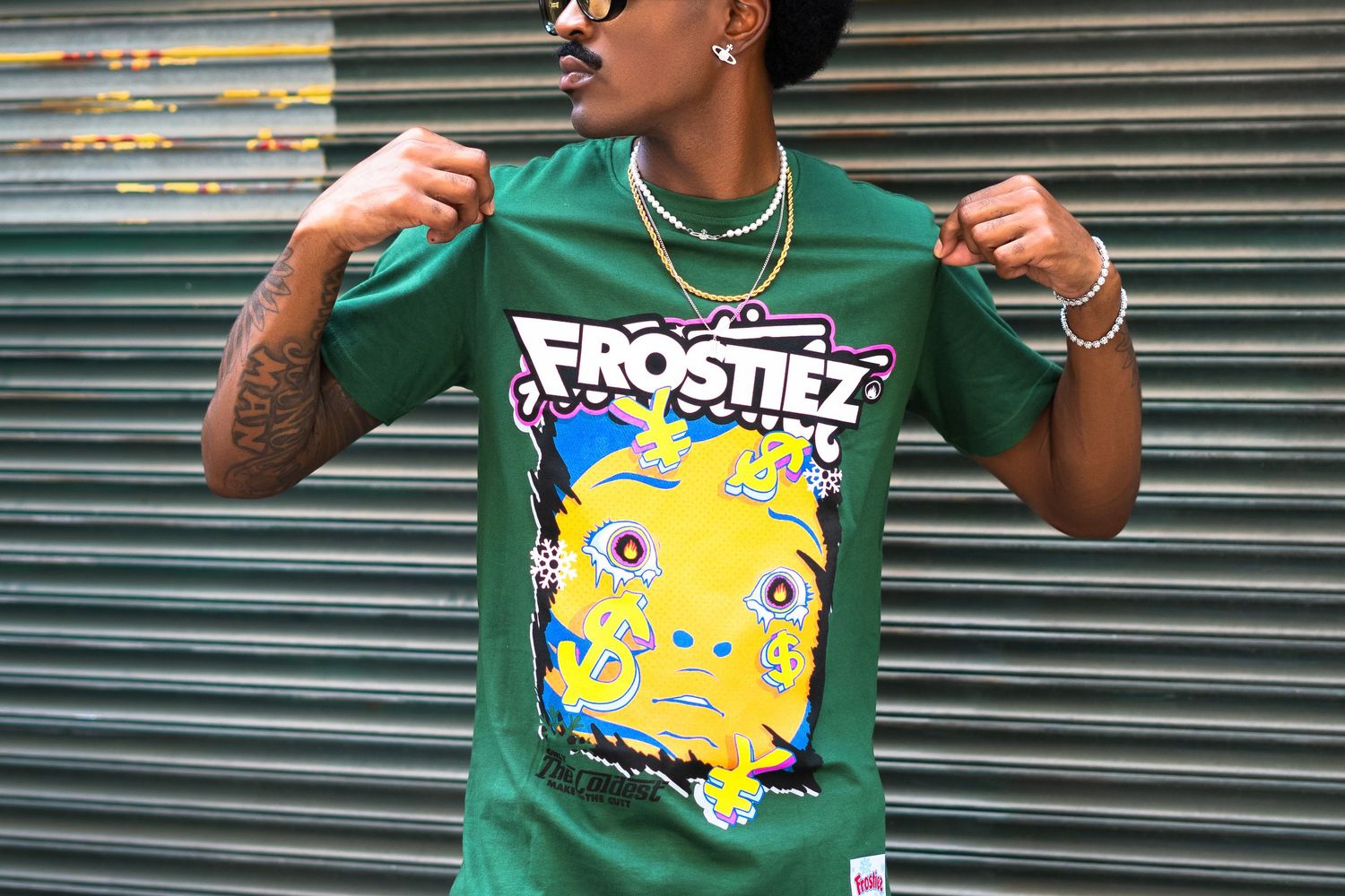 Close-up of green t-shirt with colorful cartoon monster graphic design and text.