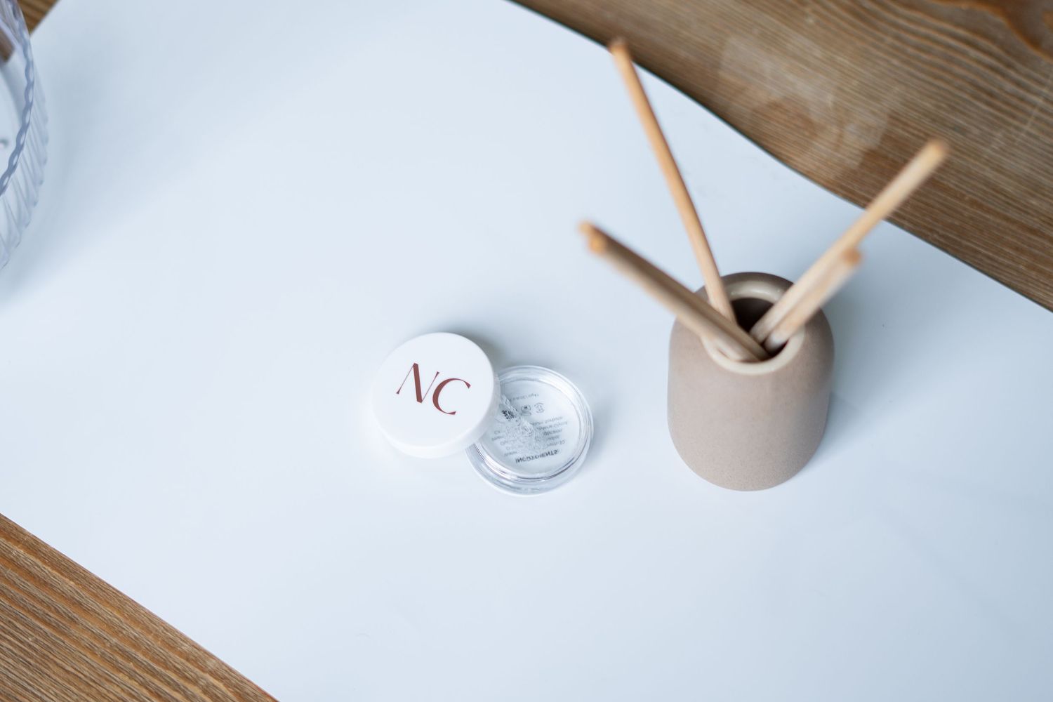 Minimal flatlay composition with drinking straws and glasses on white surface.