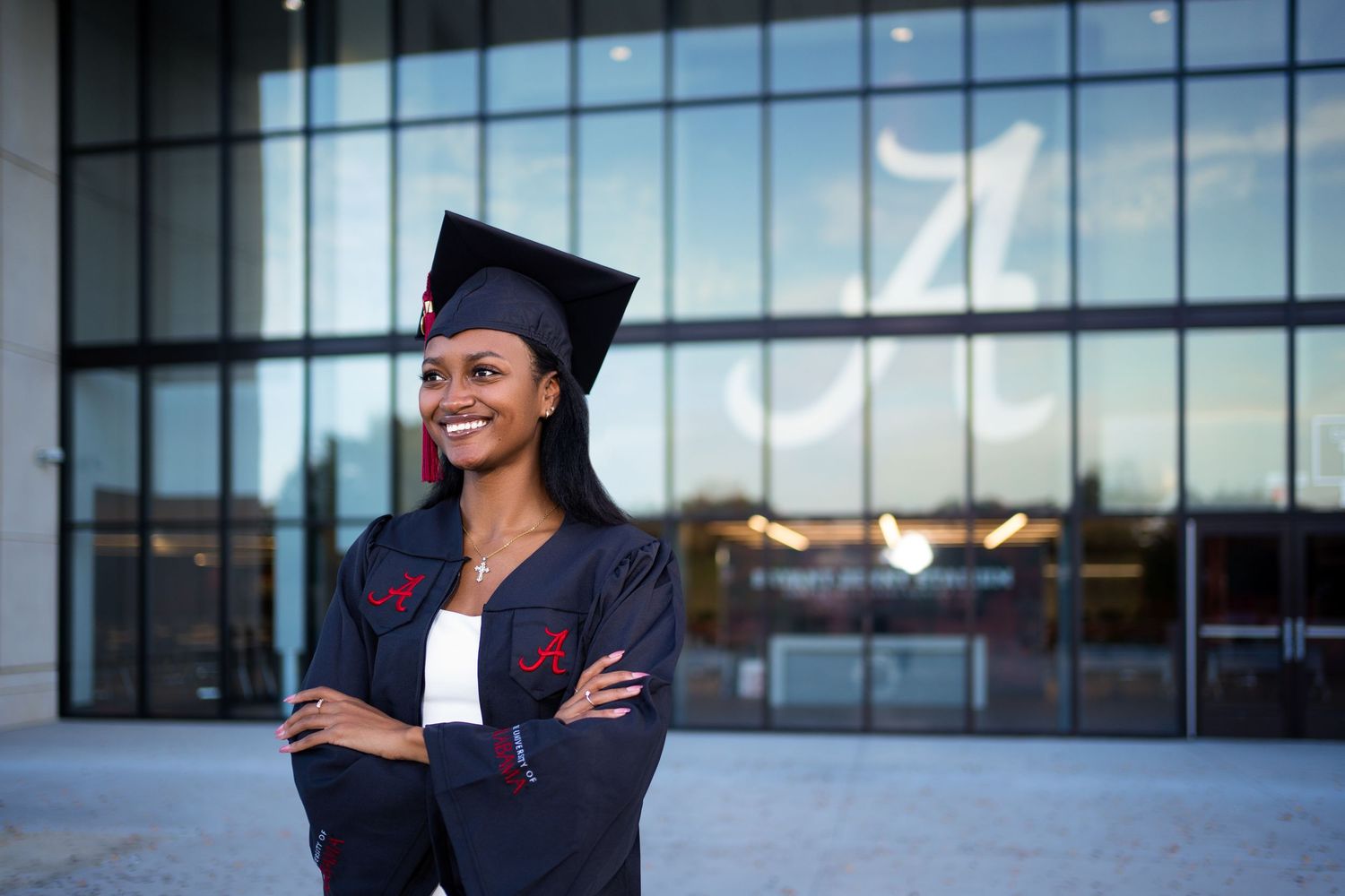 Architectural graduation photos in front of a modern glass building facade.