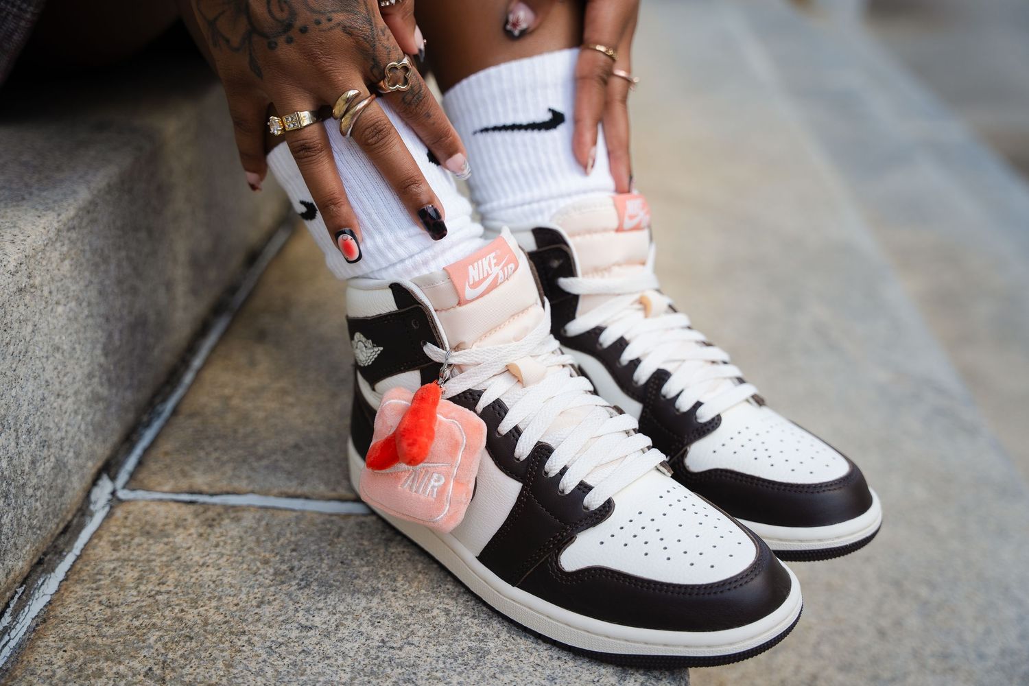 A series of photos showing someone cleaning white and black sneakers with a cleaning solution and brush.
