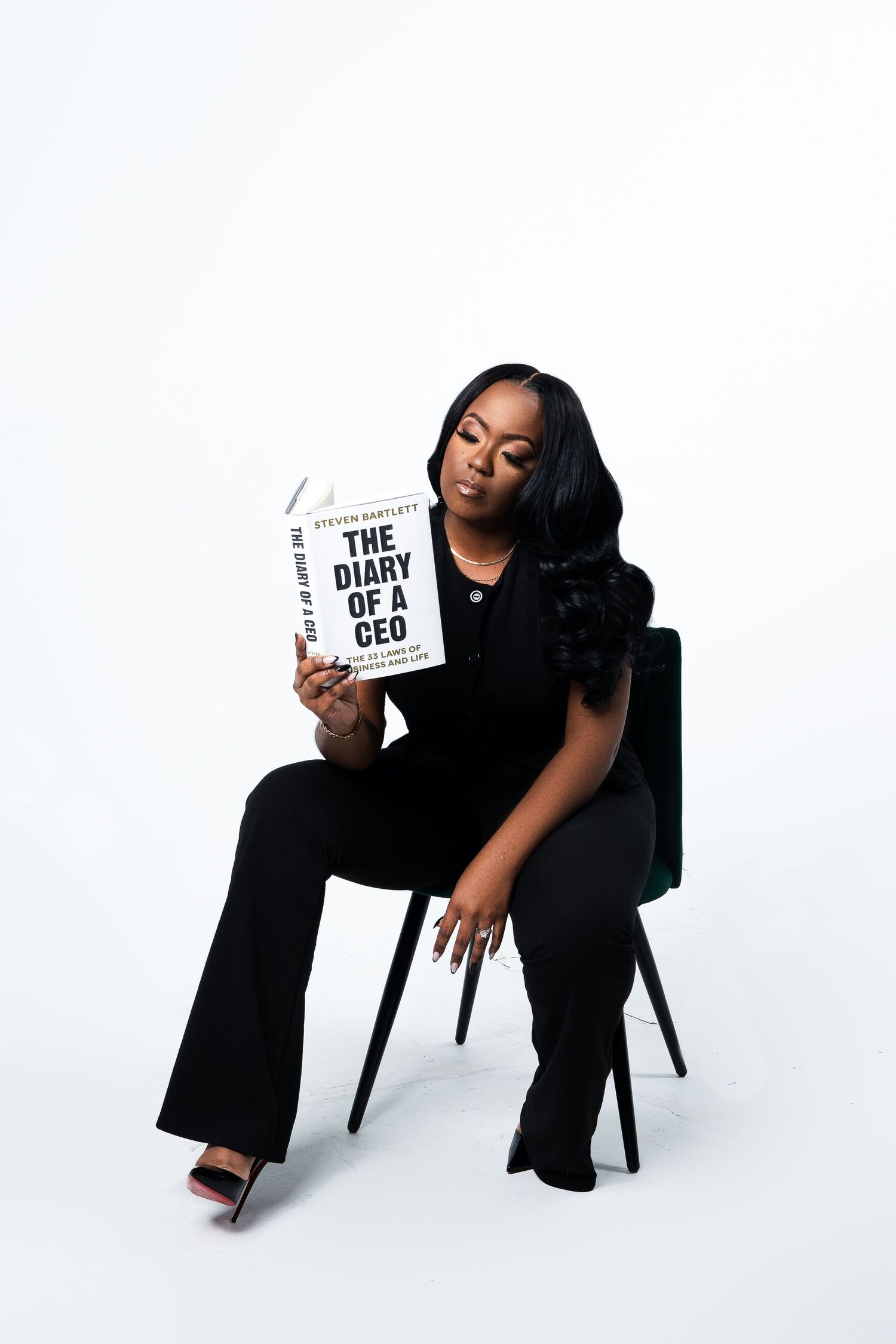 Business-themed photoshoot with book prop titled 'The Diary of a CEO' against white background.