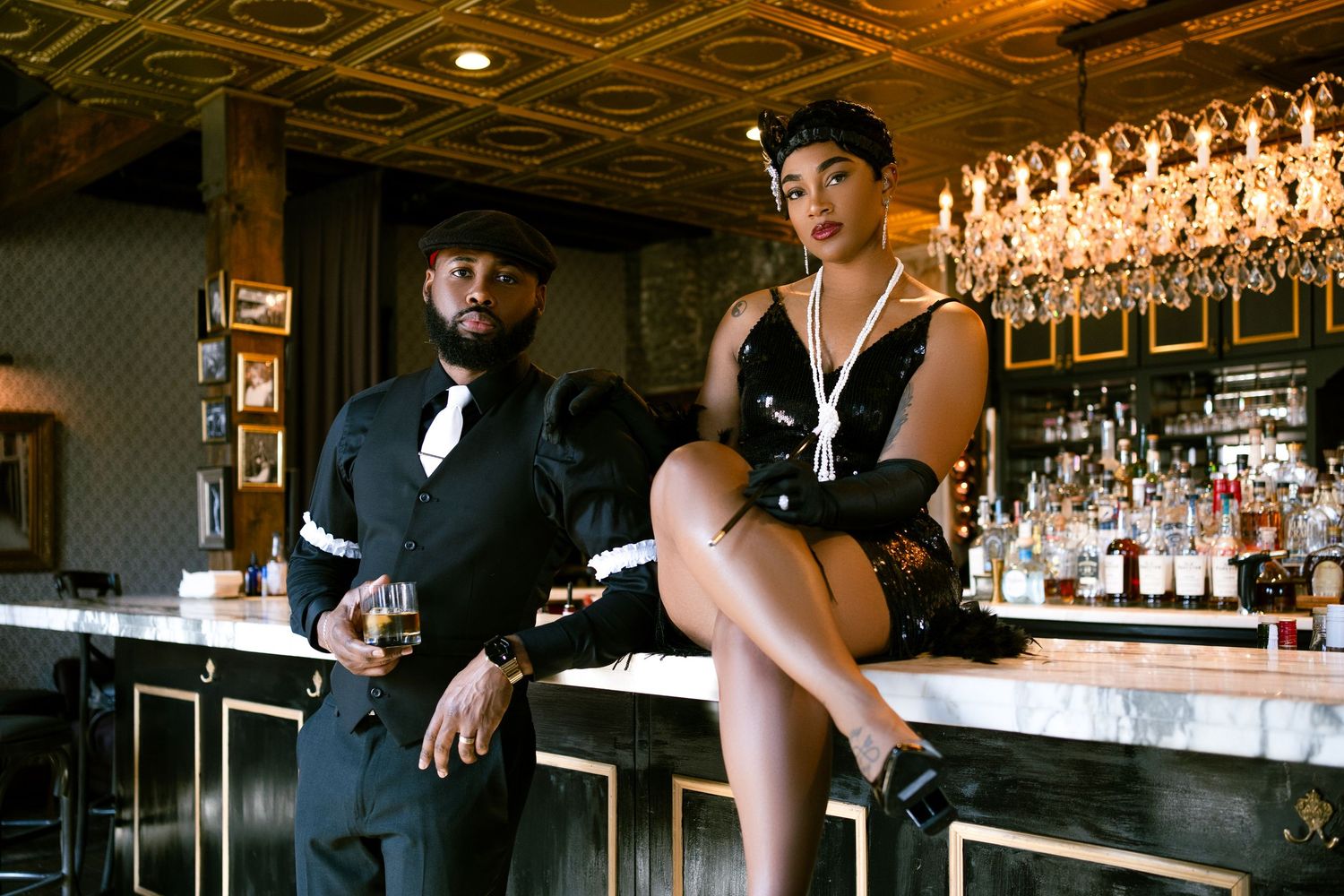 A glamorous retro-styled scene at an upscale bar with crystal chandeliers.