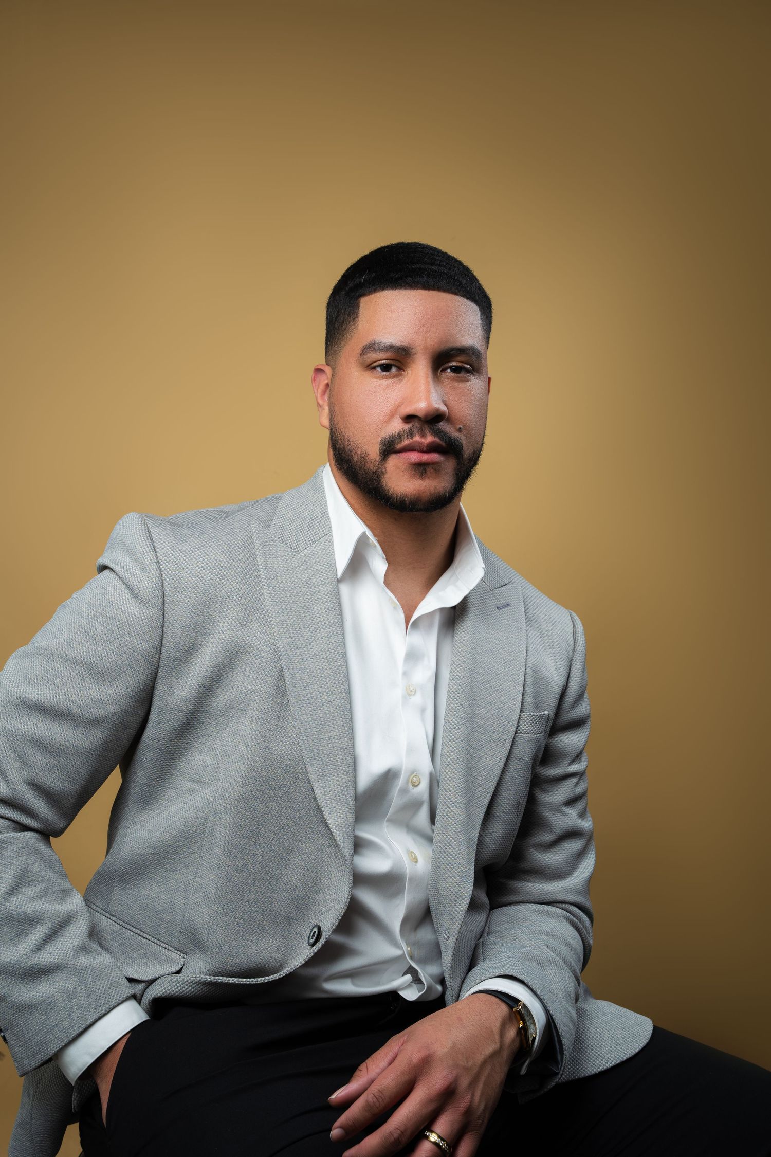 Professional studio portrait series showing someone in a gray suit jacket and white shirt against a neutral background.
