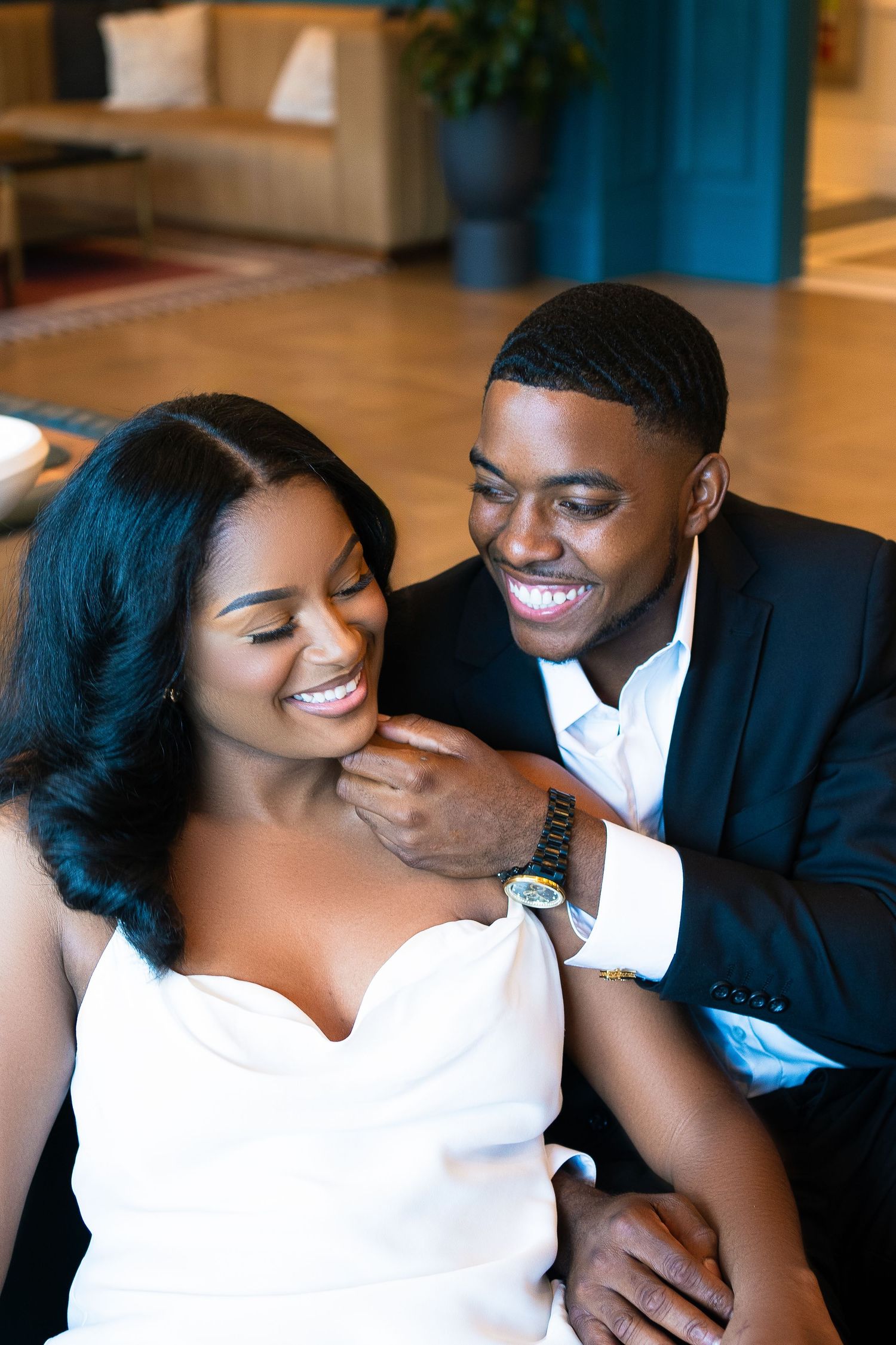 A couple shares an intimate moment while dressed elegantly indoors.