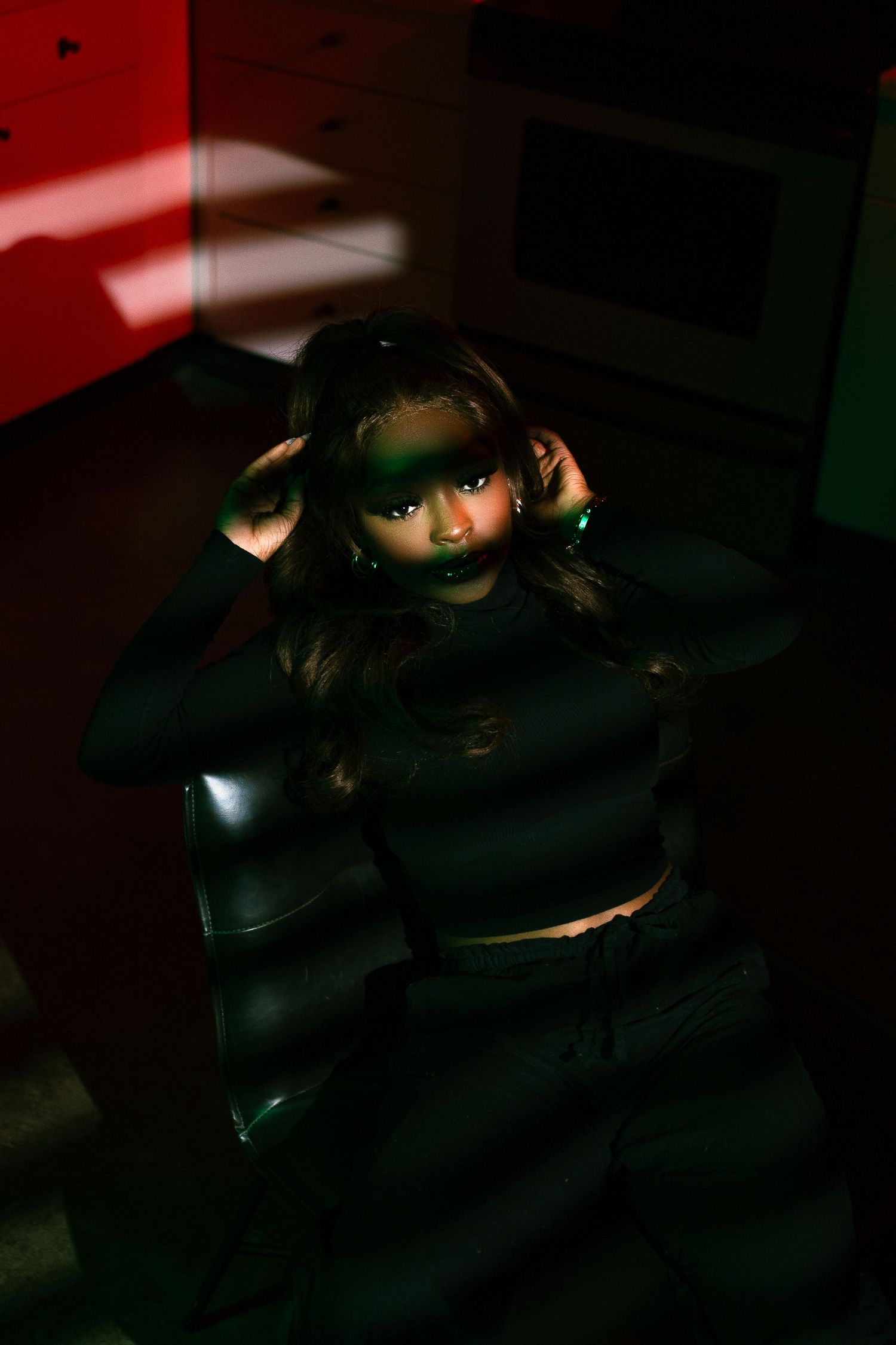 Artistic portrait with red and green lighting effects creating dramatic shadows and highlights.