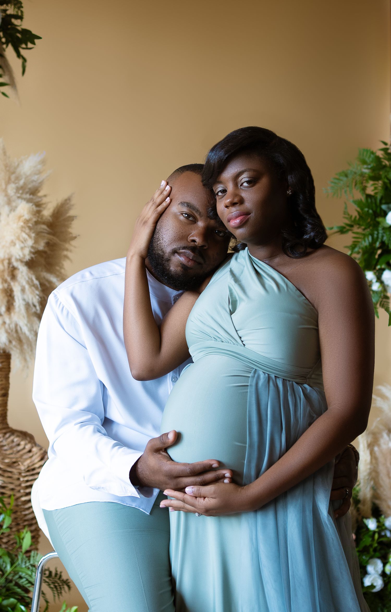 Intimate couple portrait session with matching mint blue outfits against neutral backdrop.