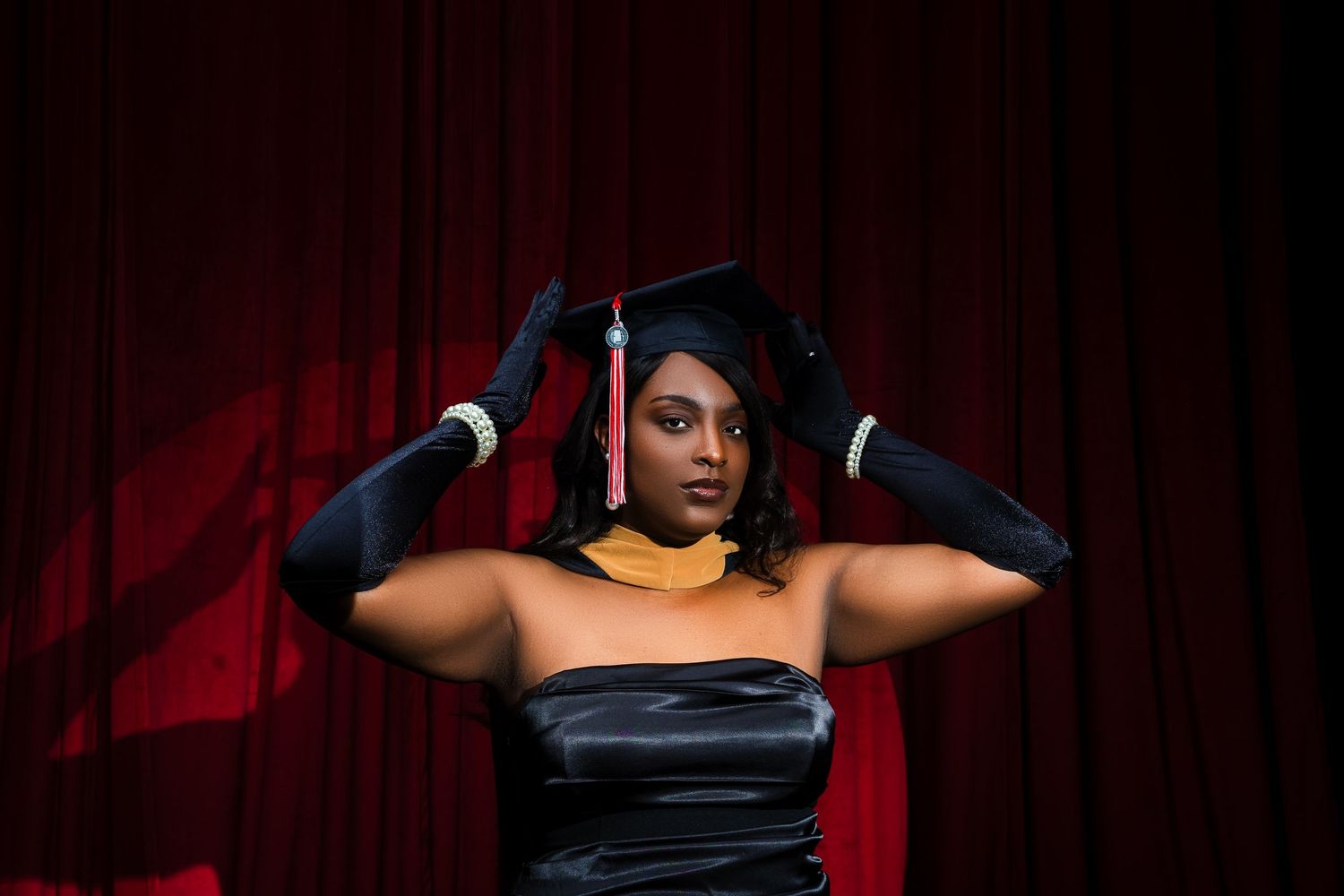 Dramatic portrait series showing a person in black against red curtains posing with various hand gestures.