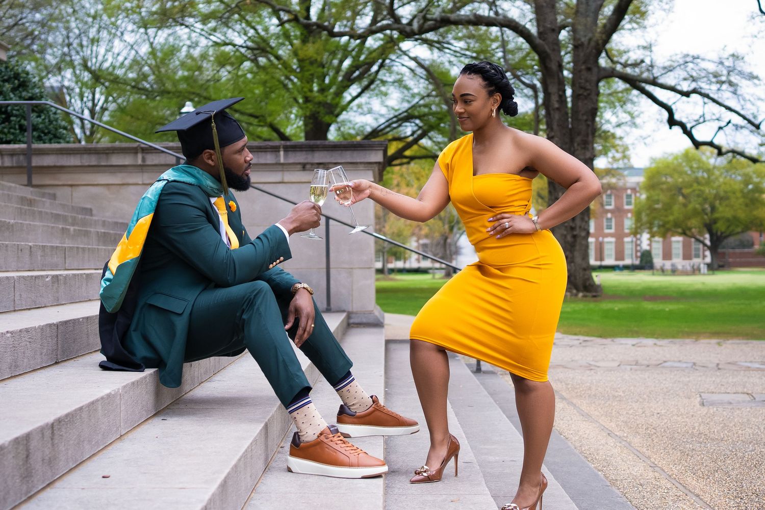 Graduation photoshoot featuring contrasting formal attire on campus steps.