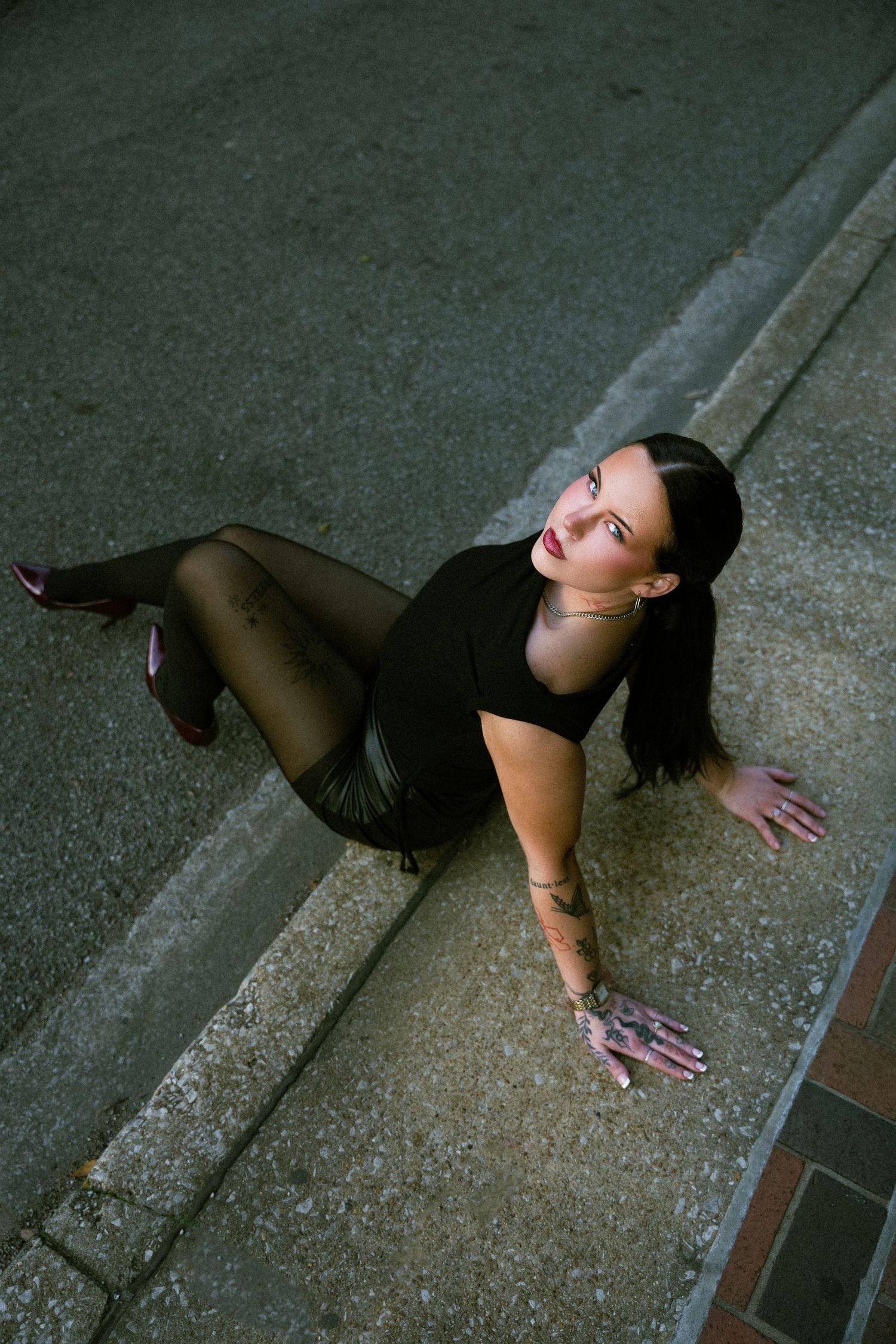 A dancer performs an expressive contemporary dance sequence on a concrete floor in dramatic lighting.