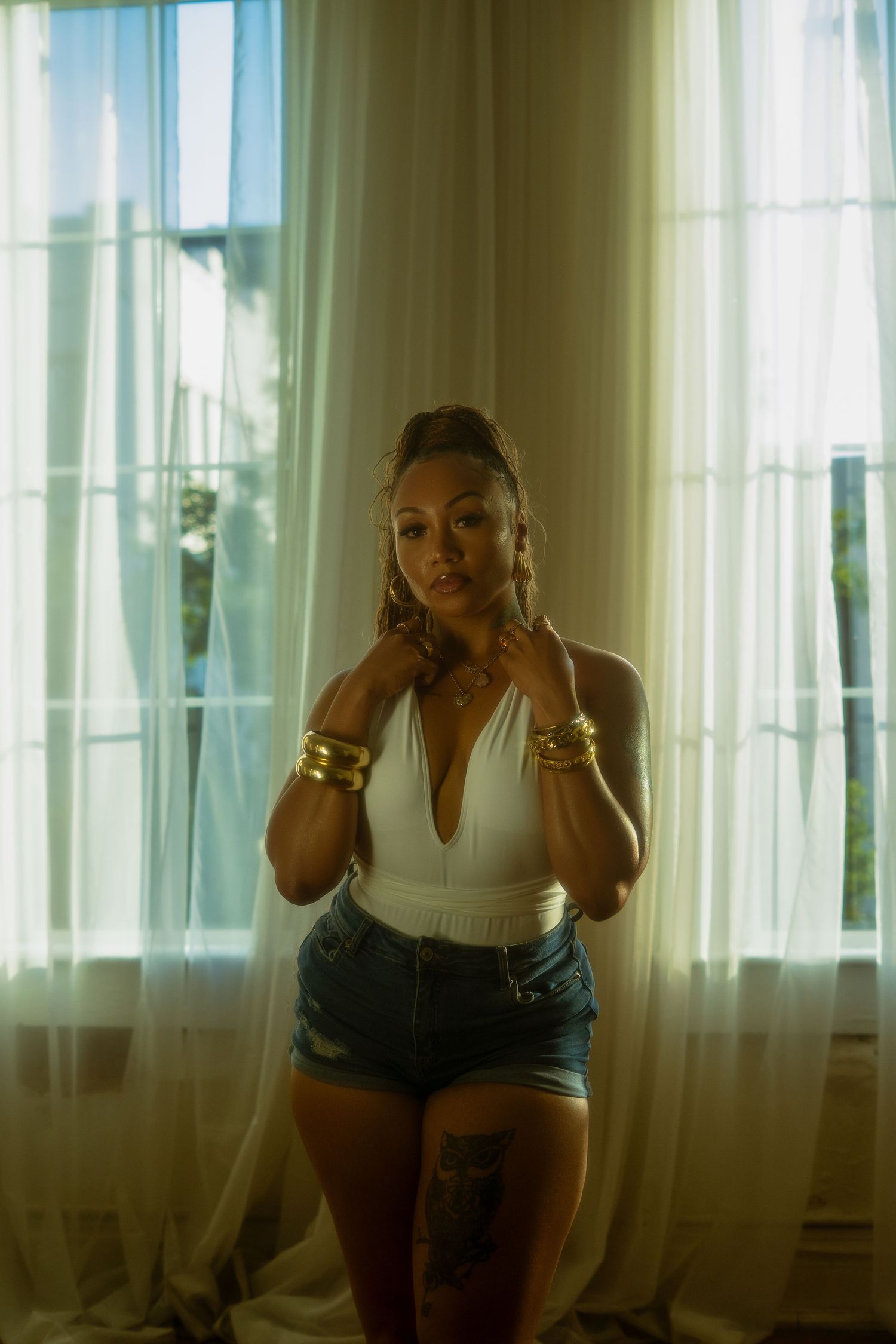 Artistic shots showing poses by a window with natural light and flowing curtains.
