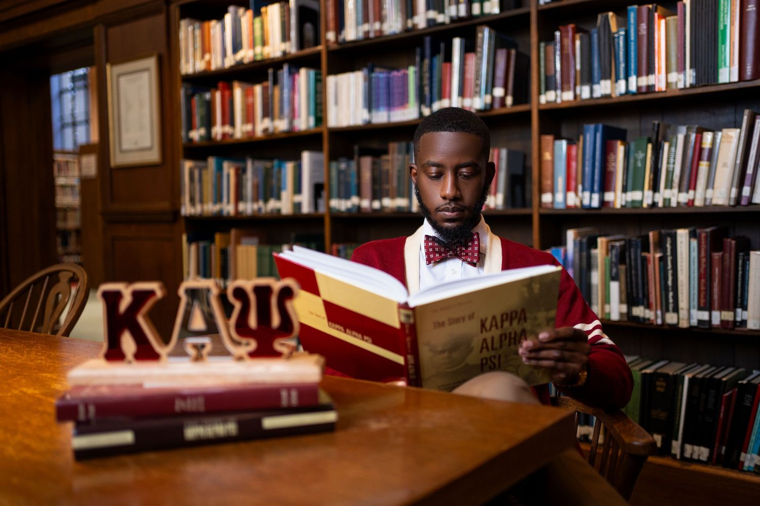 Academic environment with bookshelves and study spaces in warm-lit library.