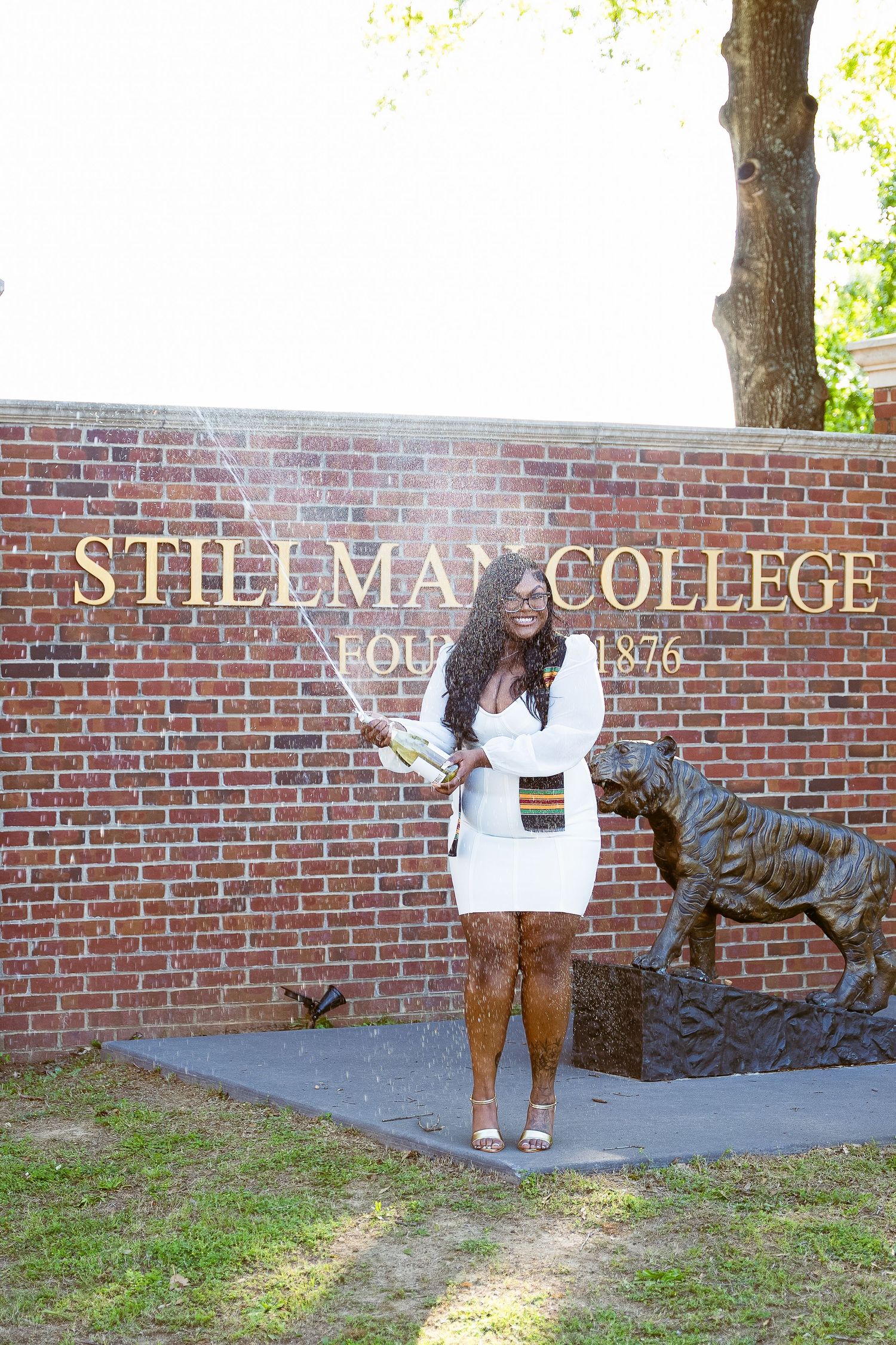 White brick wall with 'Stillman College' signage and decorative elements on a sunny day.