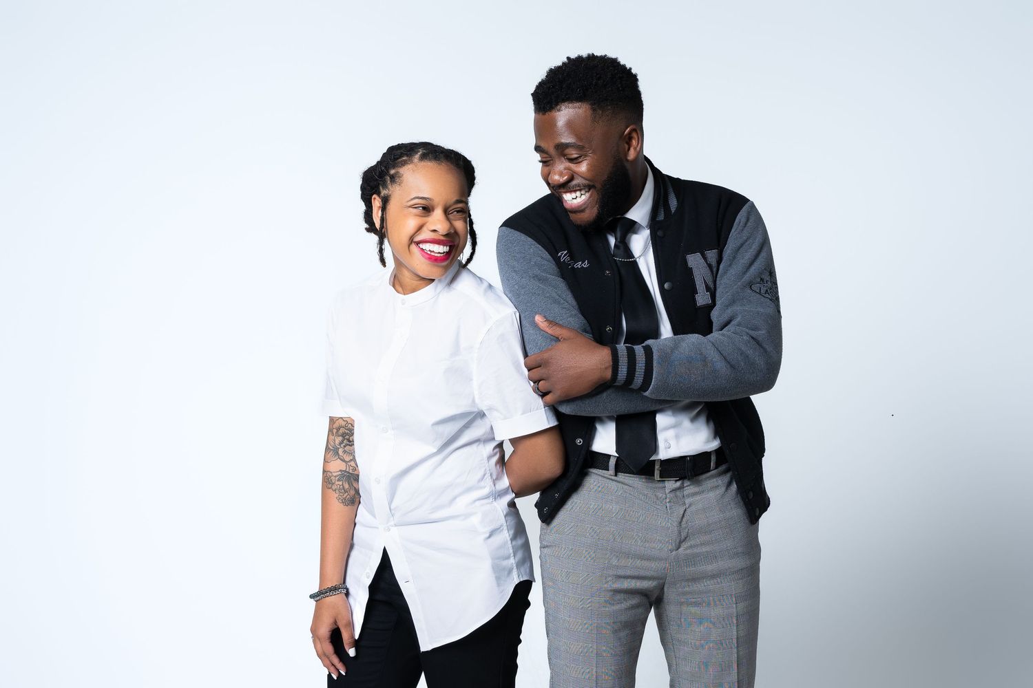 Two people sharing a joyful moment together while dressed in business casual attire.