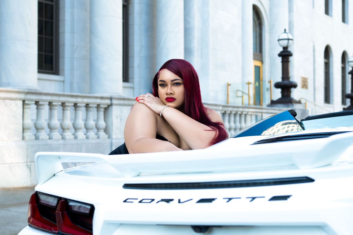 Sleek white sports car photographed against classical architecture.