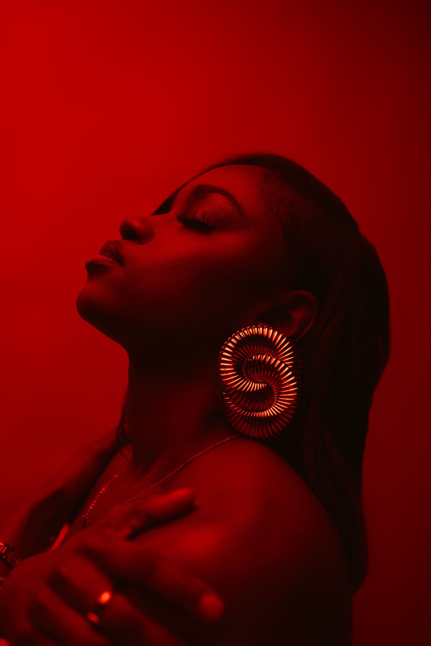 A dramatic sequence of silhouetted profiles against a deep red background with glowing circular elements near the eyes.