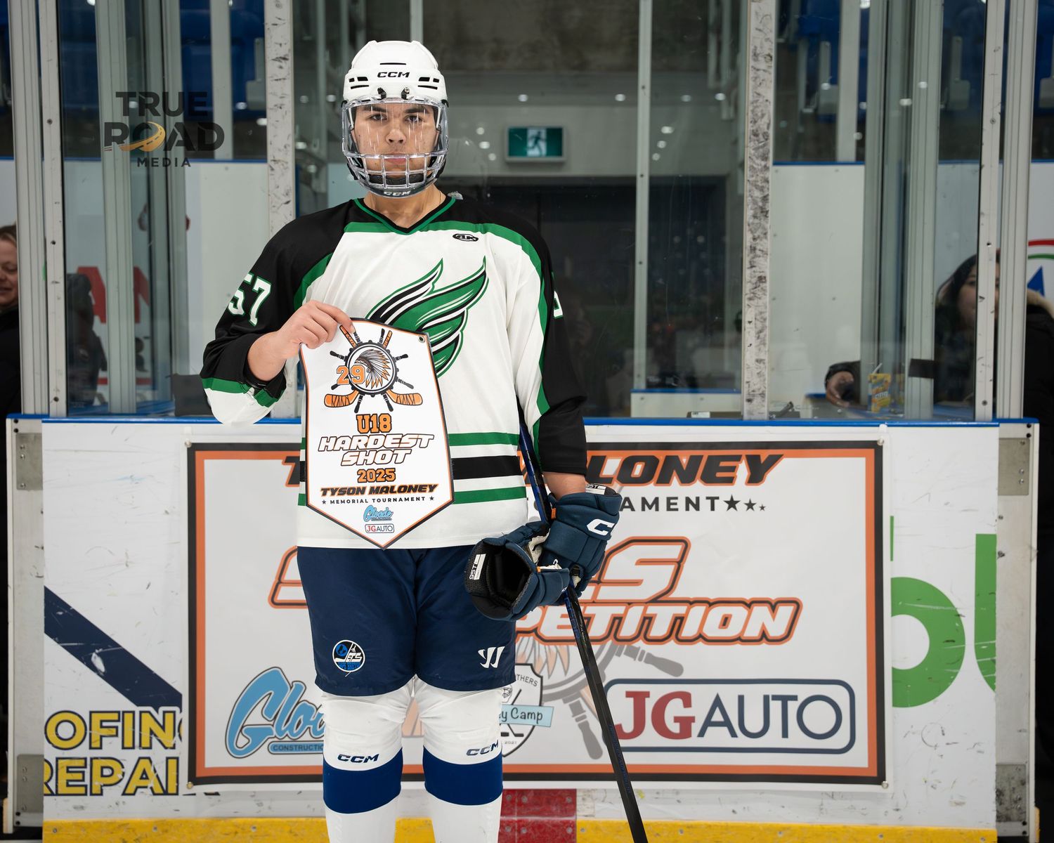 Hockey players in different colored jerseys practicing on an indoor rink with sponsor signage.