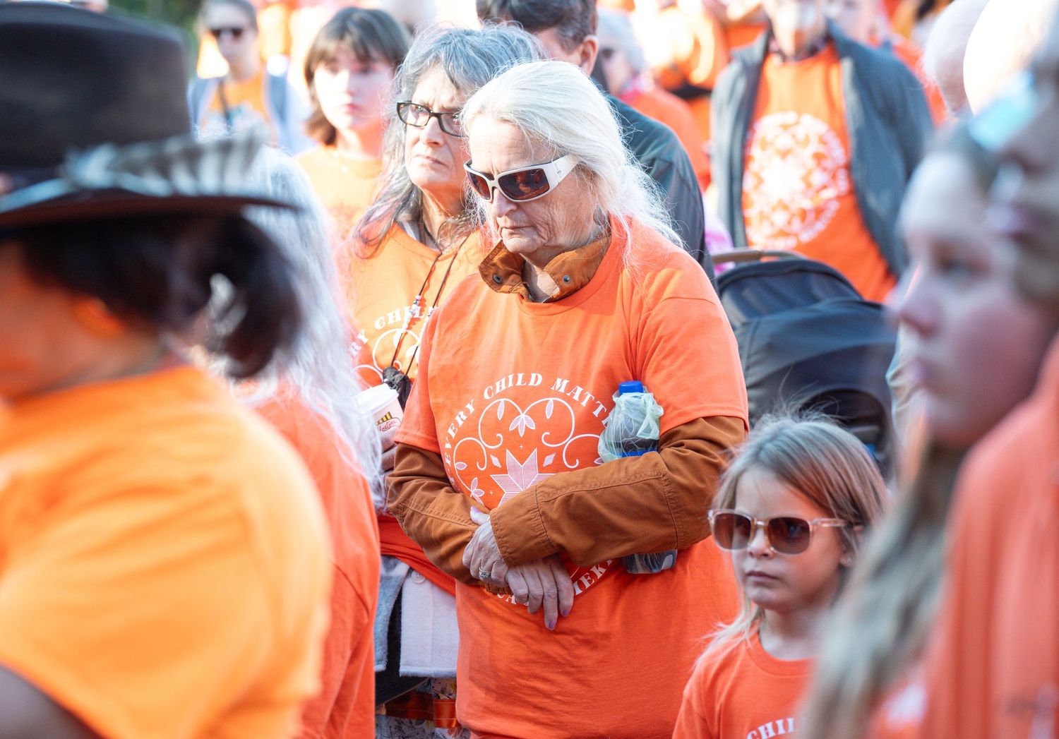 Large crowd wearing orange shirts gathered together at a community event.